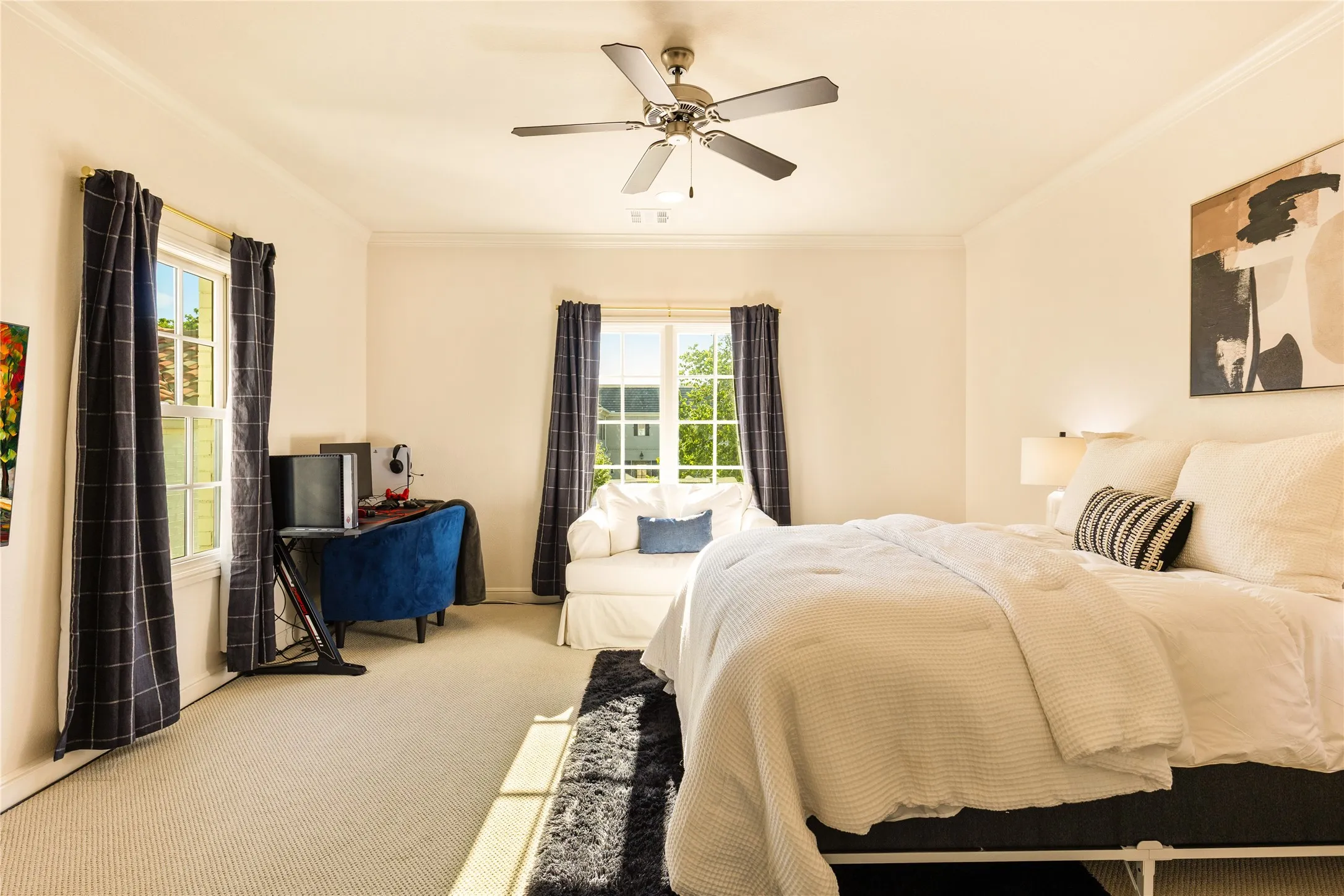 Spacious secondary bedroom features soft carpet flooring, abundant natural light, and a bright, comfortable layout perfect for family or guests.
