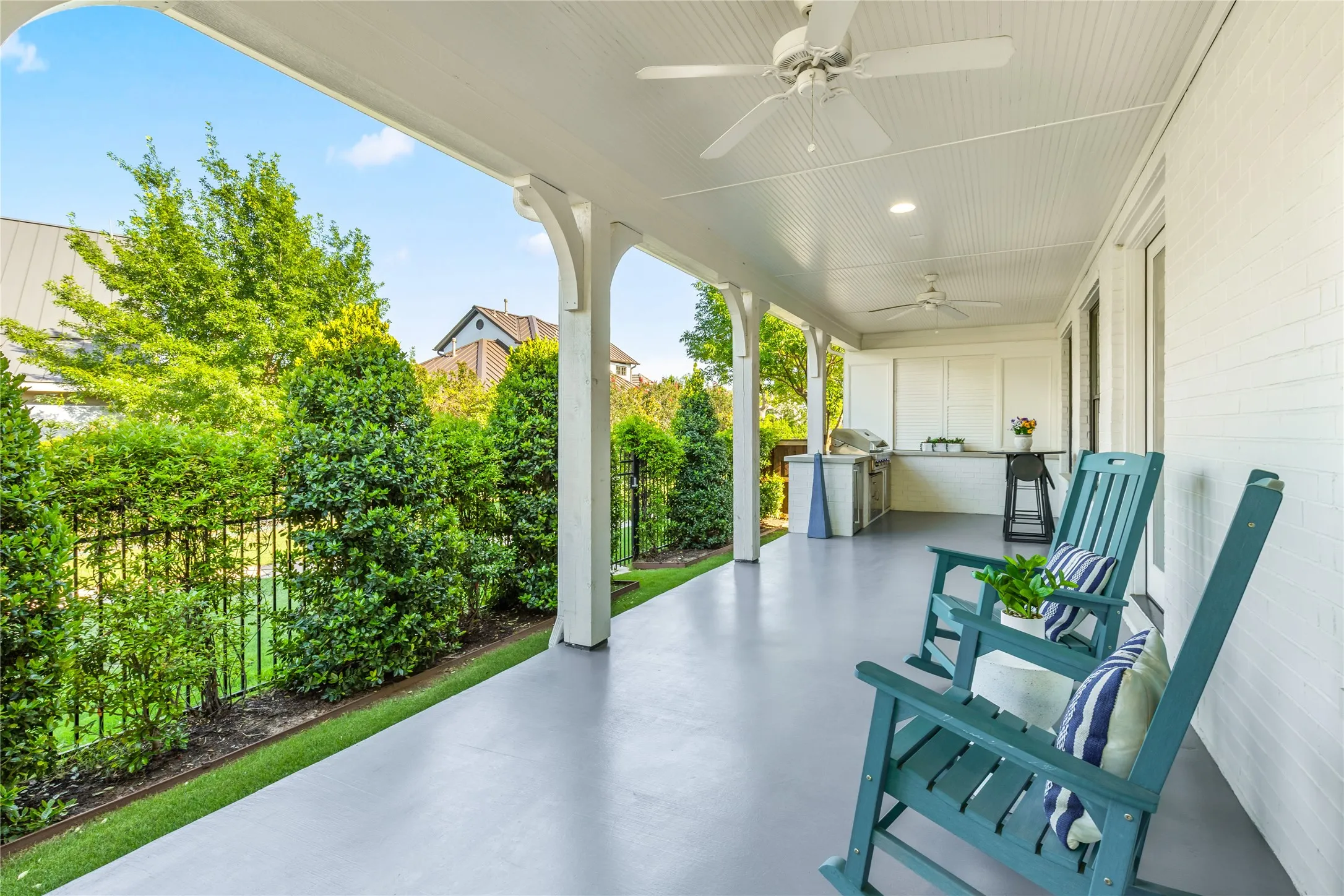Outdoor kitchen and covered patio create an ideal entertaining space with built in grilling, bar seating, and peaceful views of the surrounding greenery.