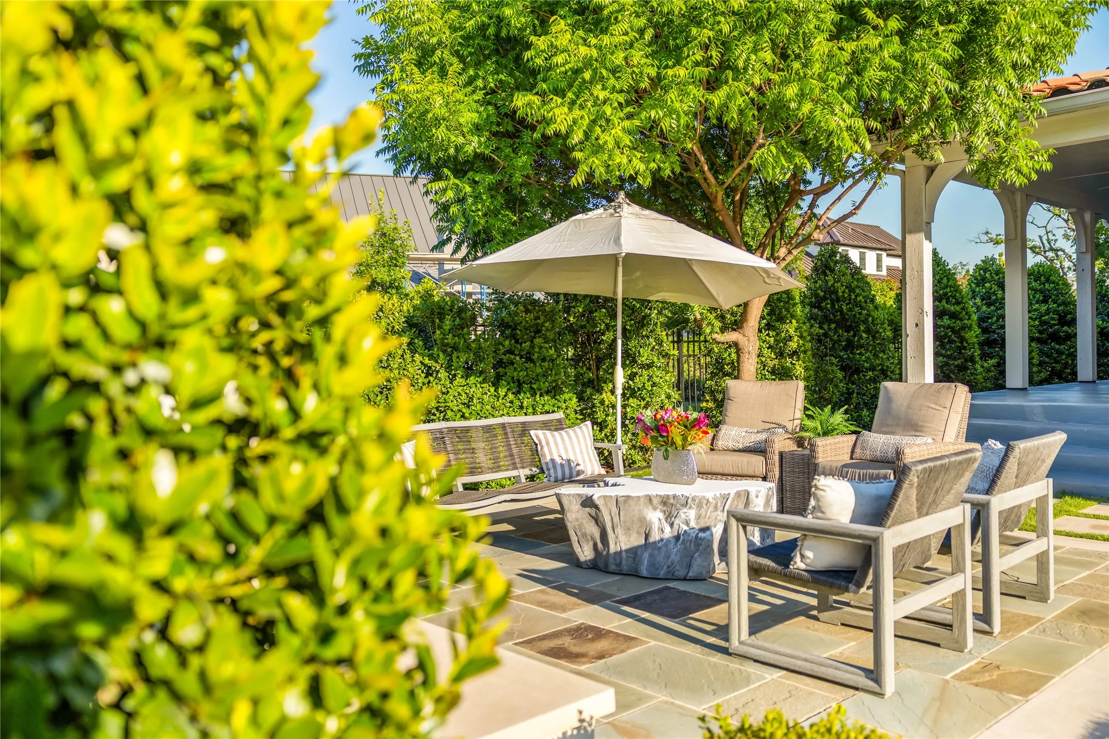 Resort style outdoor living area features multiple seating spaces, lush landscaping, and a private patio setting designed for relaxing and entertaining year round.