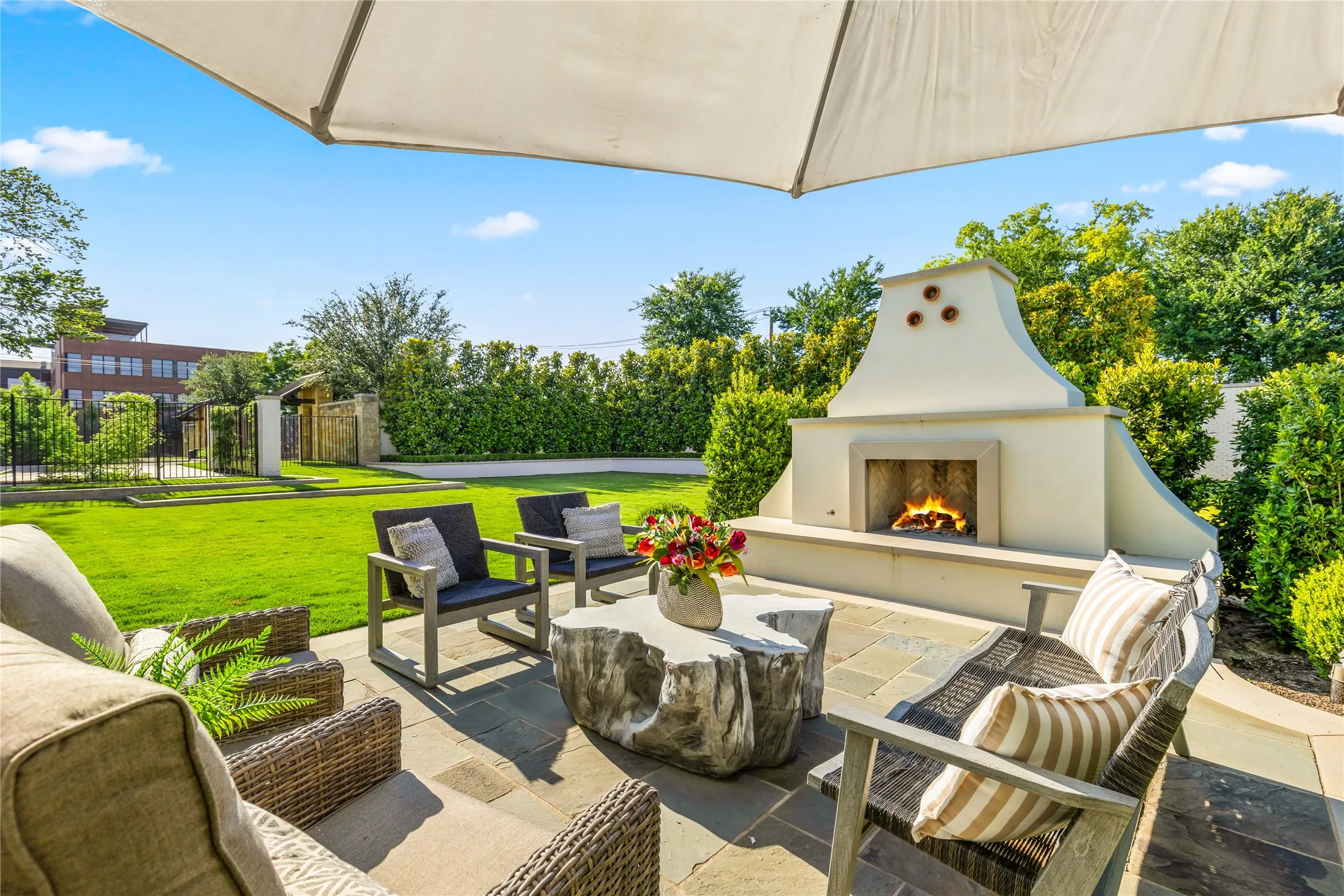 Resort style outdoor living area features multiple seating spaces, lush landscaping, and a private patio setting designed for relaxing and entertaining year round.