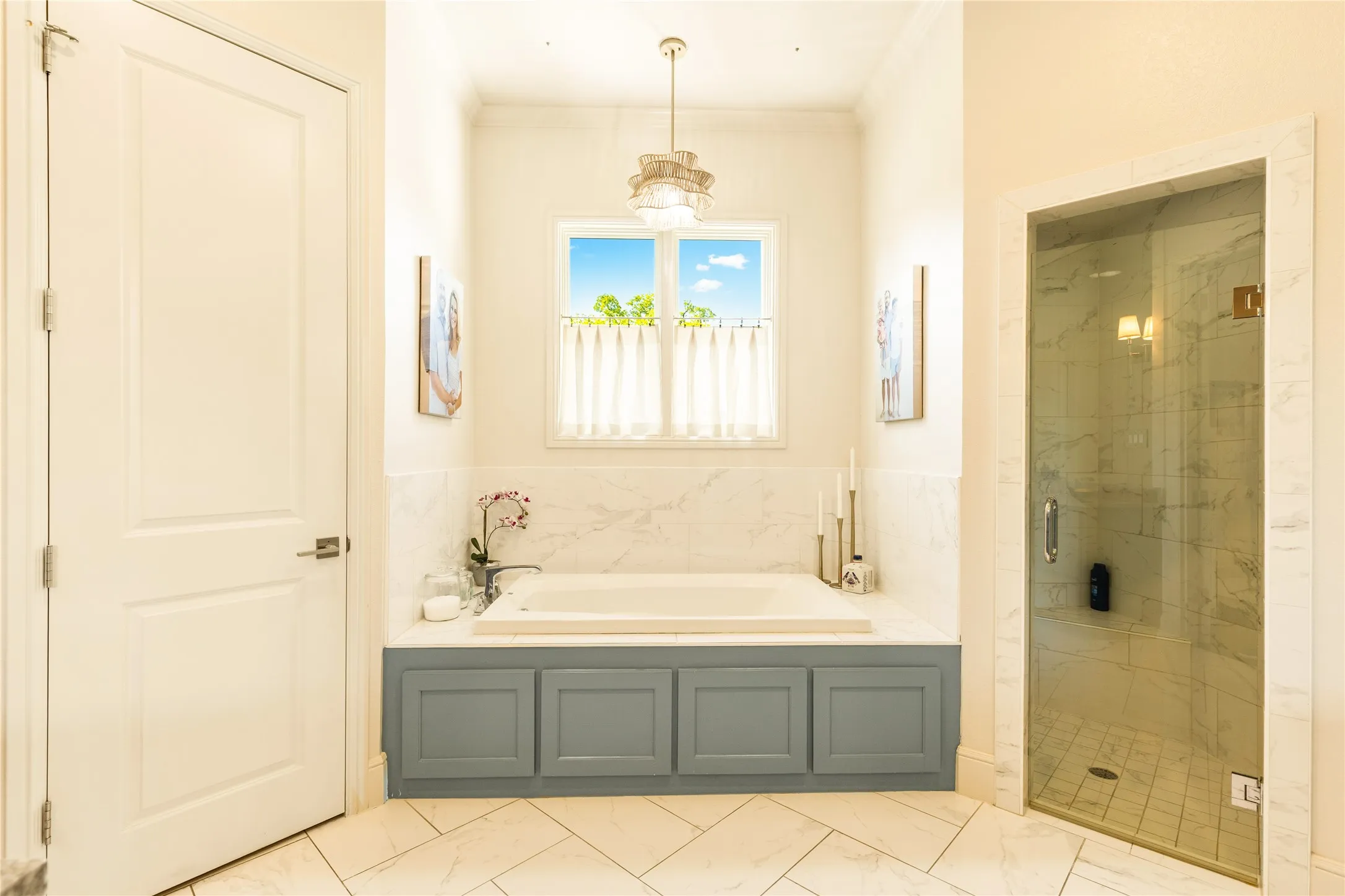 Spa inspired primary bath features dual vanities, elegant finishes, and abundant natural light that creates a bright and relaxing retreat.