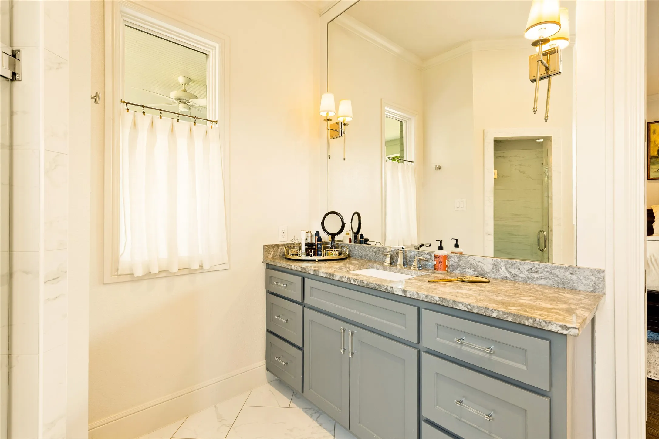 Spa inspired primary bath features dual vanities, elegant finishes, and abundant natural light that creates a bright and relaxing retreat.