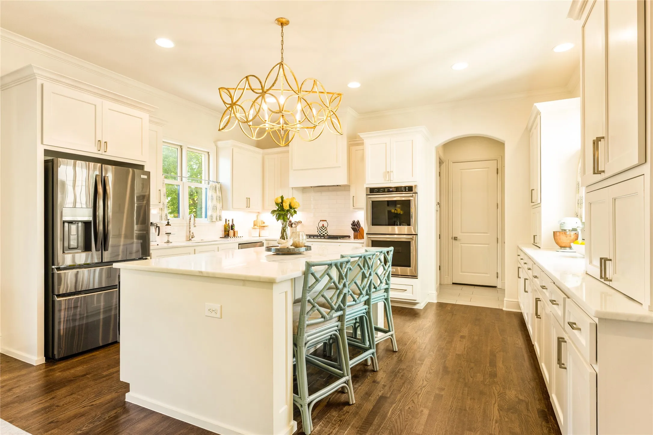 Chef’s kitchen features an oversized island with designer lighting, premium stainless steel appliances, and an open layout ideal for both everyday living and entertaining.