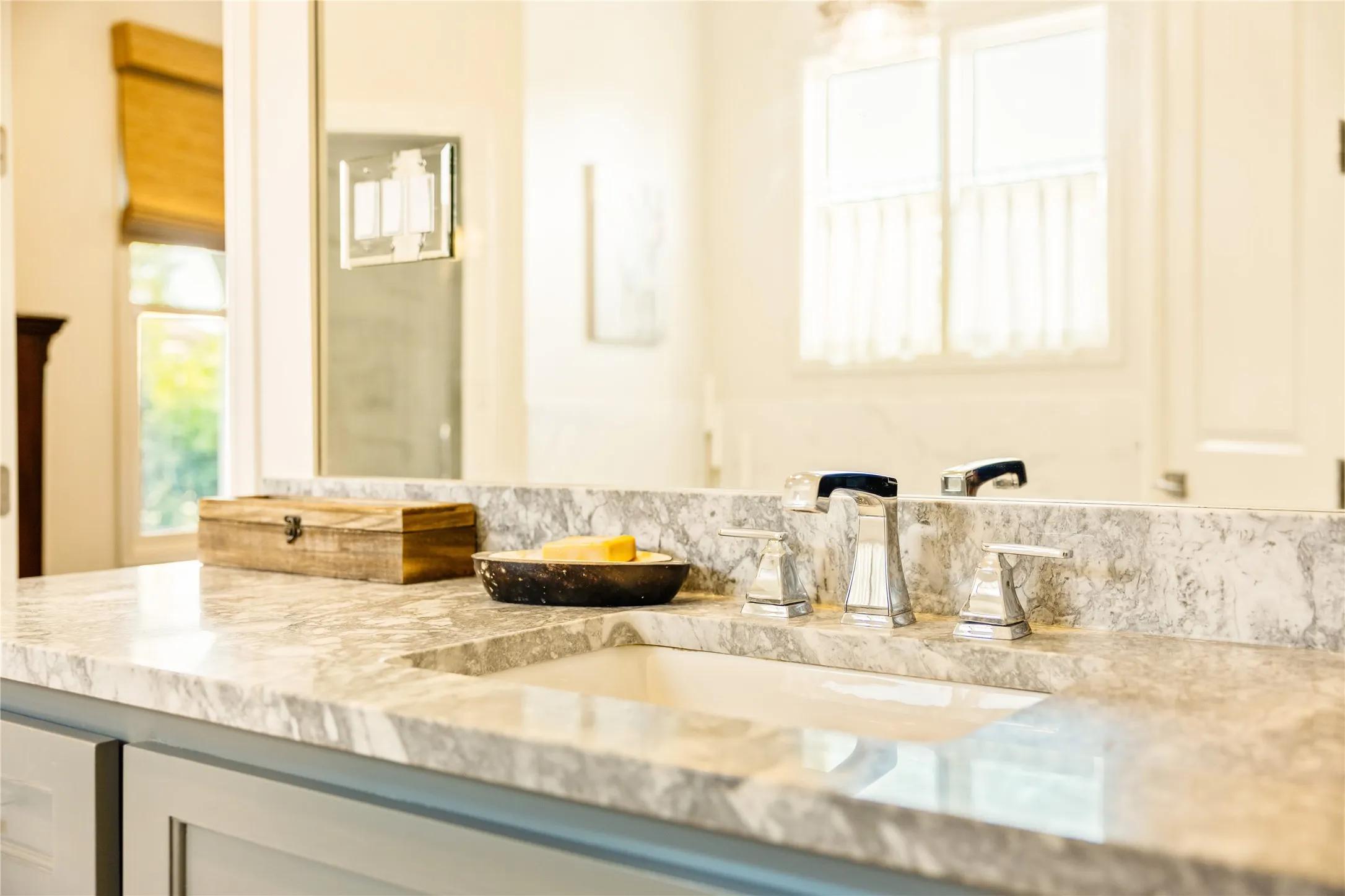 Spa inspired primary bath features dual vanities, elegant finishes, and abundant natural light that creates a bright and relaxing retreat.