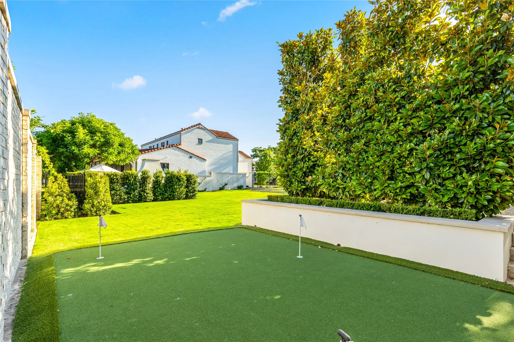 Private putting green offers a fun and versatile outdoor retreat, surrounded by mature landscaping that creates a peaceful and secluded setting.