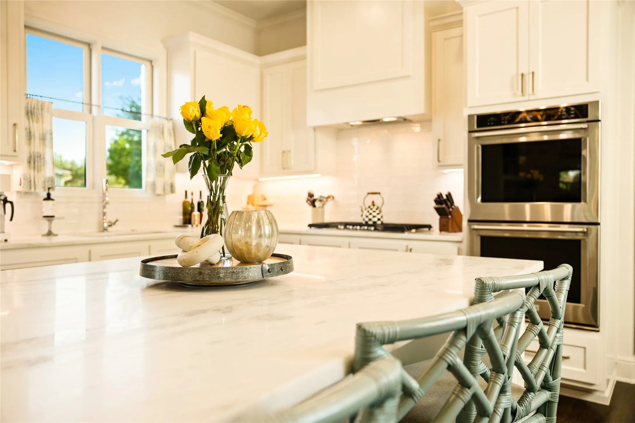 Chef’s kitchen features an oversized island with designer lighting, premium stainless steel appliances, and an open layout ideal for both everyday living and entertaining.