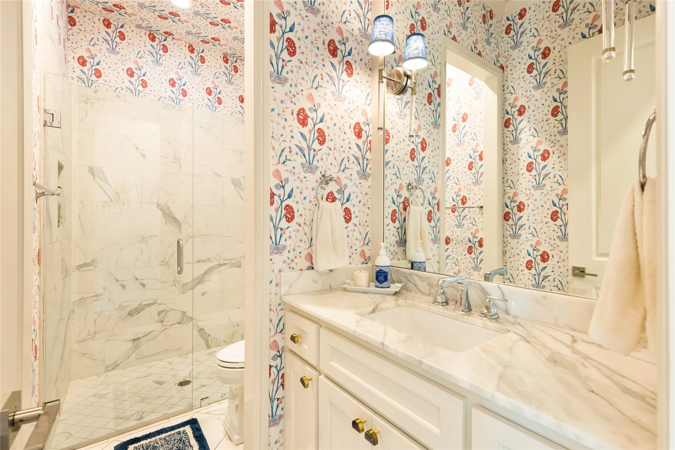 Elegant bathroom showcases designer wallpaper, refined finishes, and timeless details that add charm and sophistication to the home.