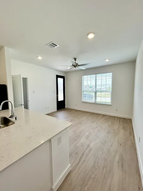 Open-concept living space featuring wood-finish flooring, recessed lighting, and a ceiling fan