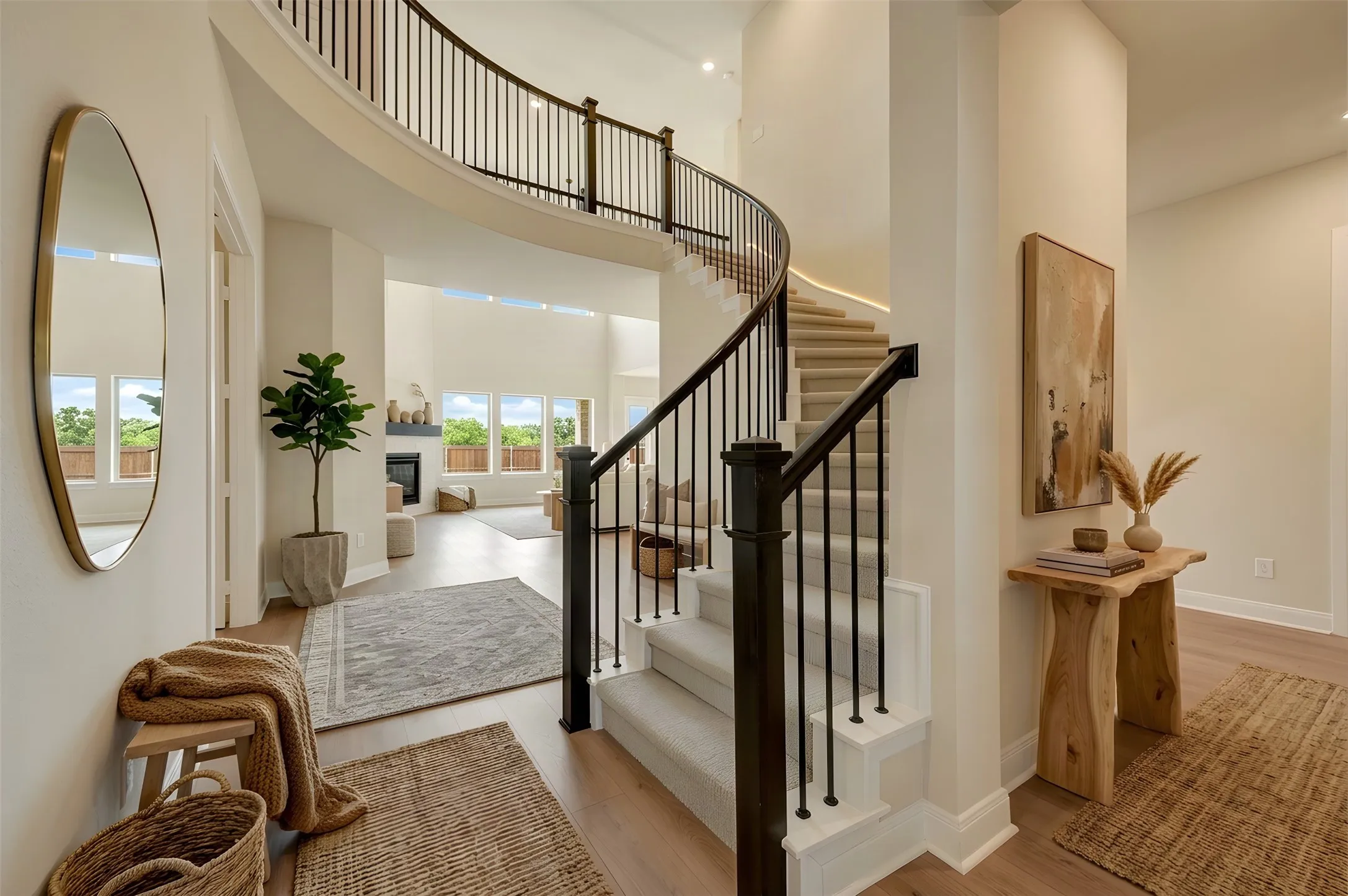 Curved staircase with black metal balusters, carpeted treads, and wood-finish flooring