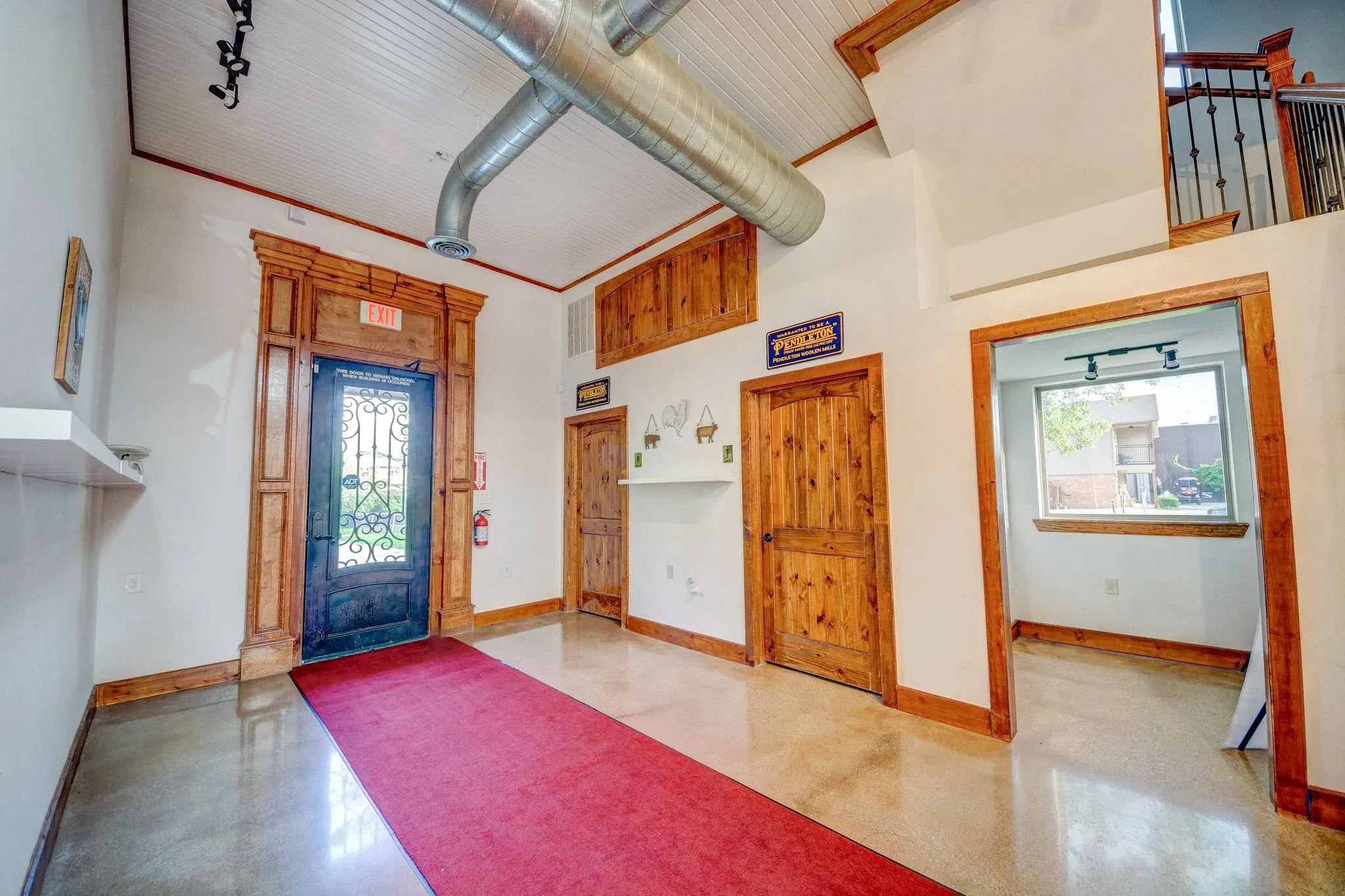 Entryway featuring a decorative iron and glass door with ornate wood-finish trim