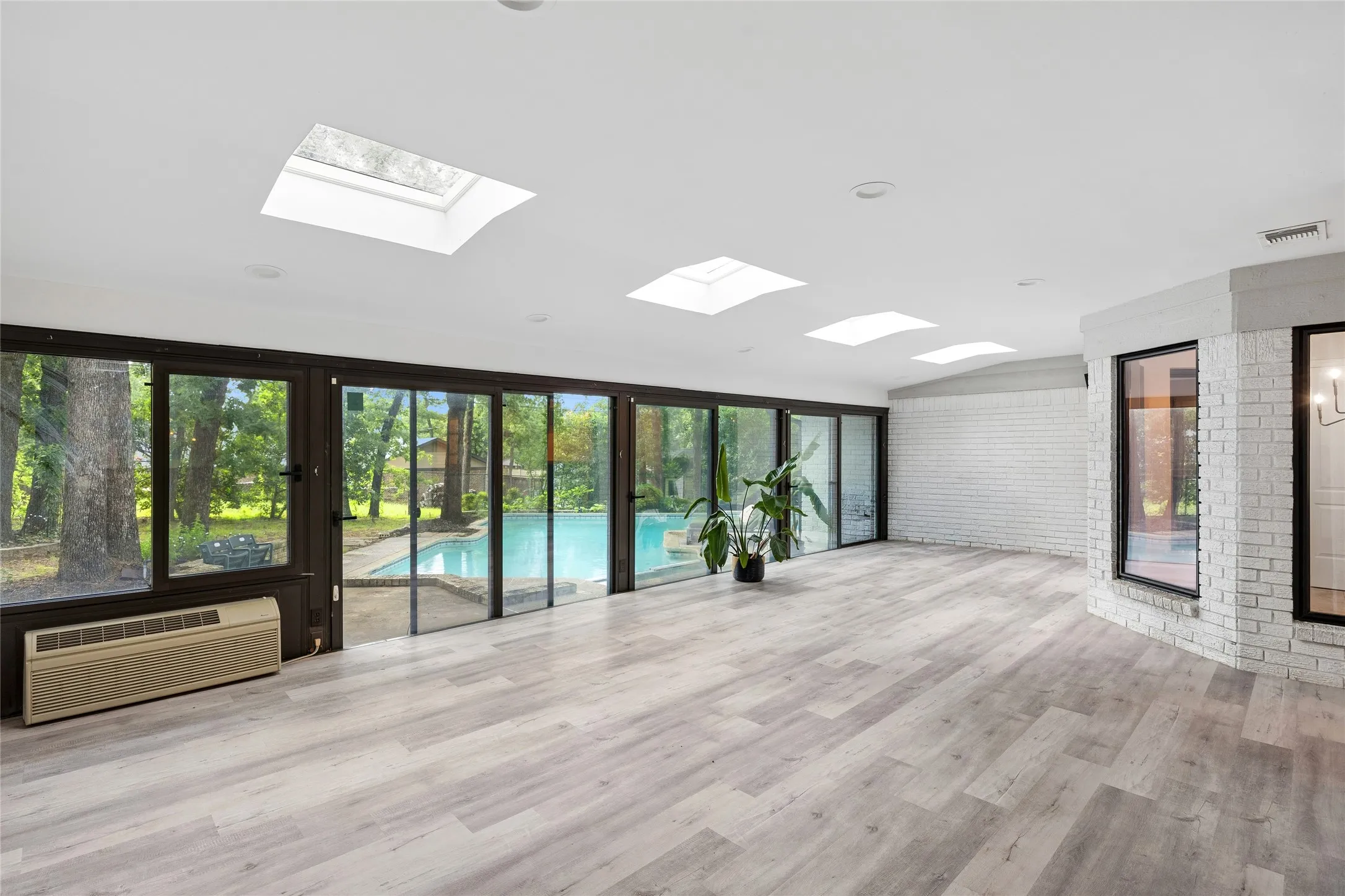 Massive sun room with floor to ceiling sliding glass doors and skylights