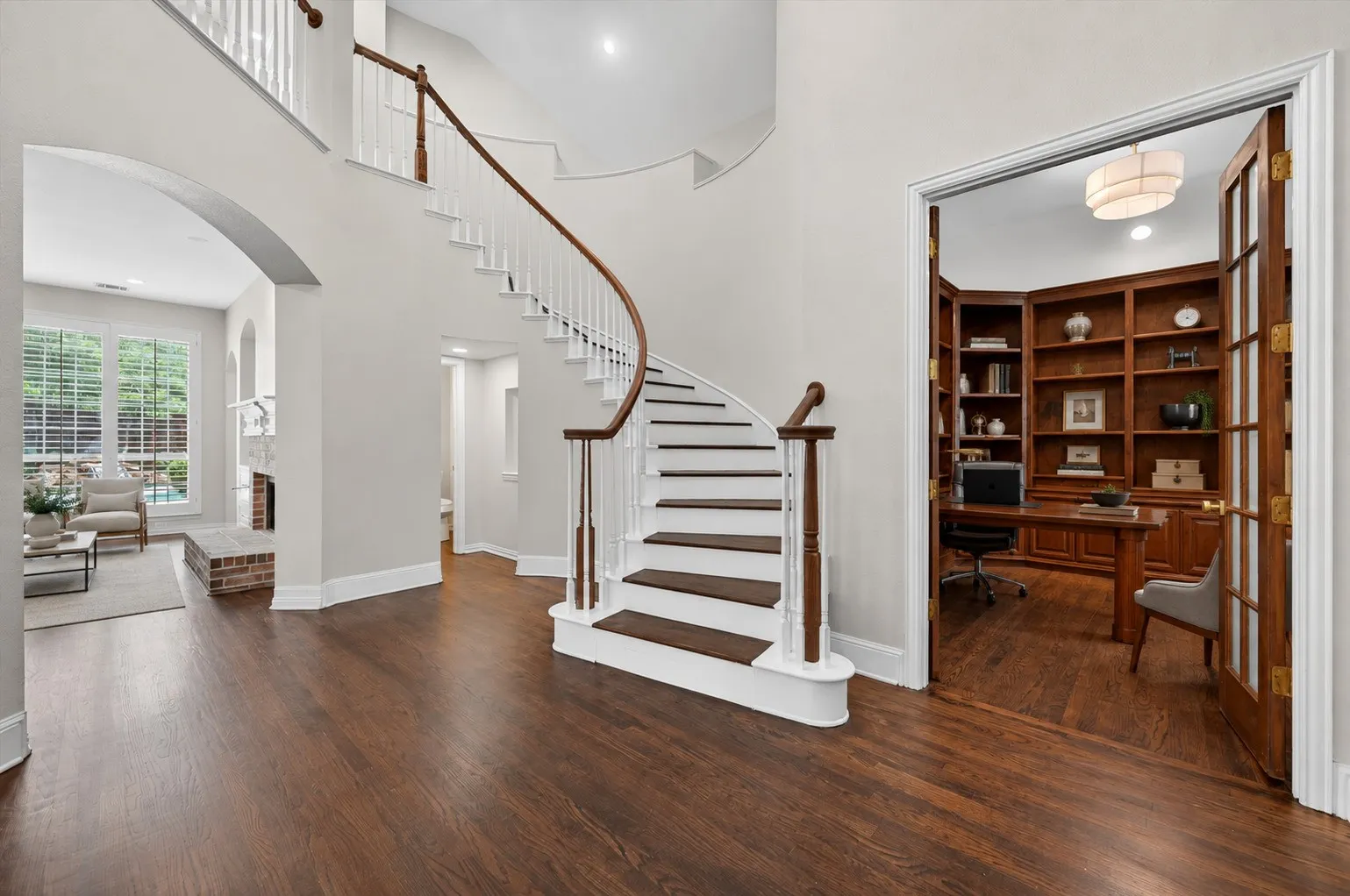 Grand curved staircase with a wood-finish handrail and balusters