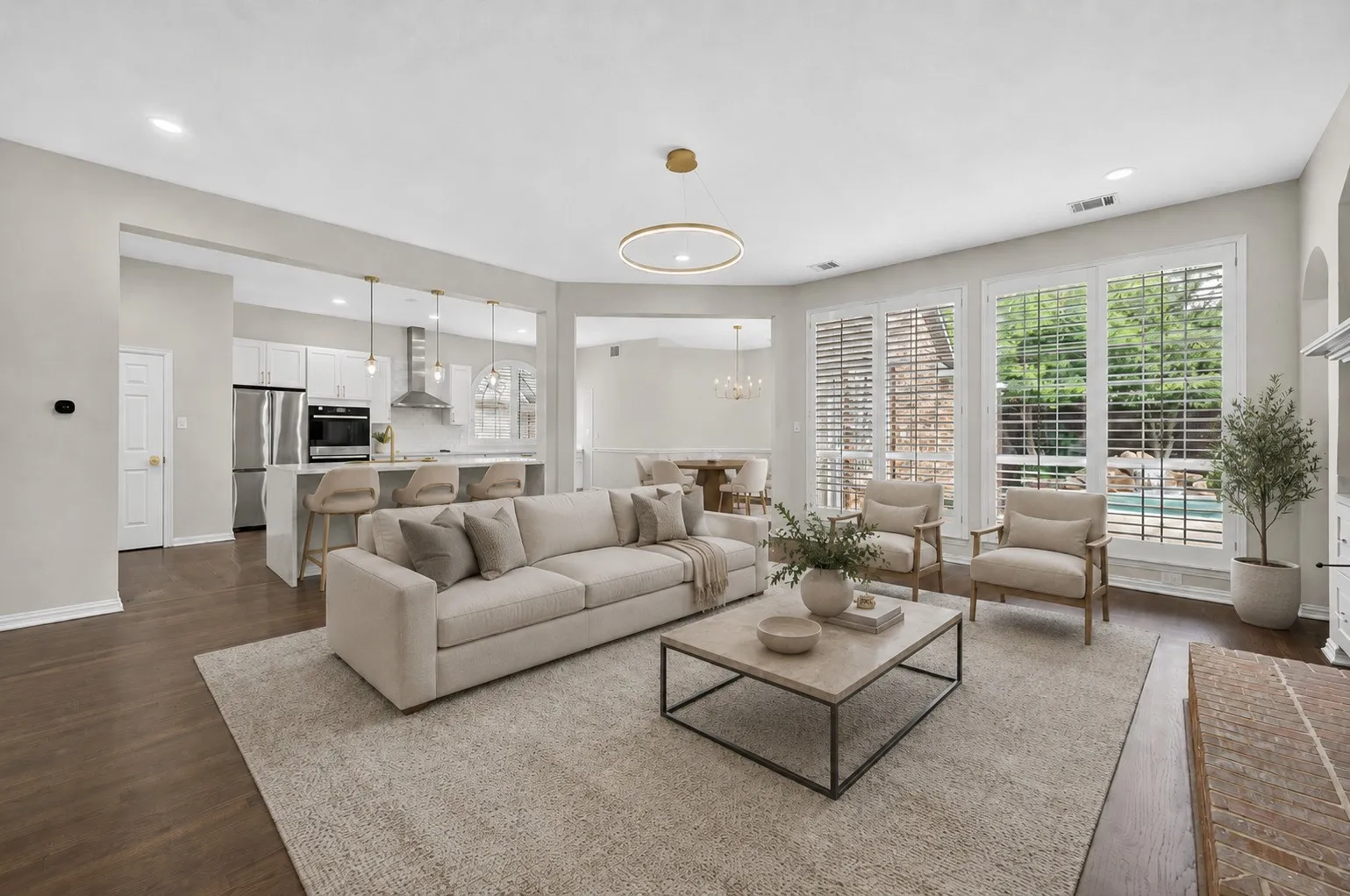 Spacious living area featuring dark wood-finish flooring, a contemporary chandelier, and recessed lighting