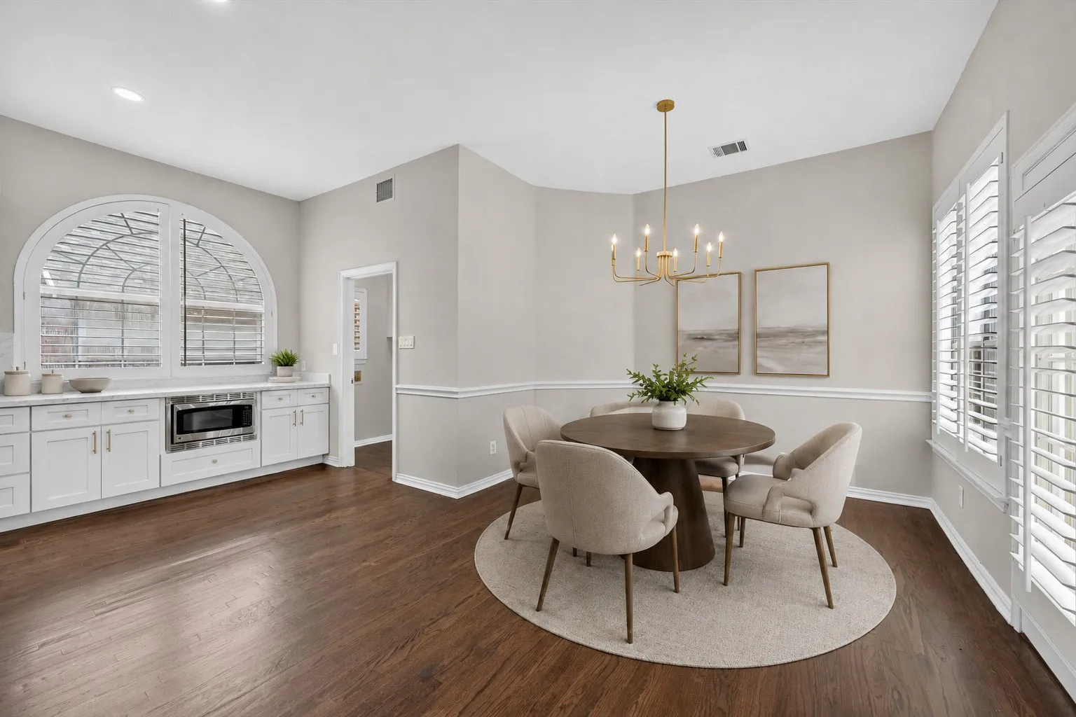 Dining area featuring dark wood-finish flooring and a contemporary gold-finish chandelier