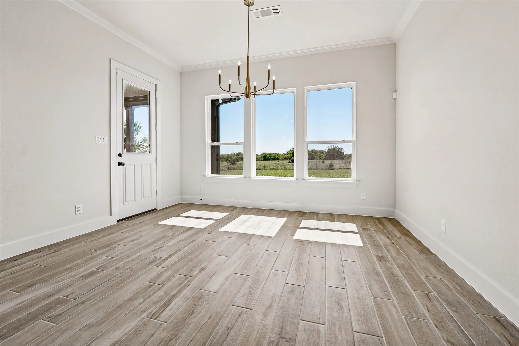 Wood-finish flooring throughout, complemented by a contemporary chandelier
