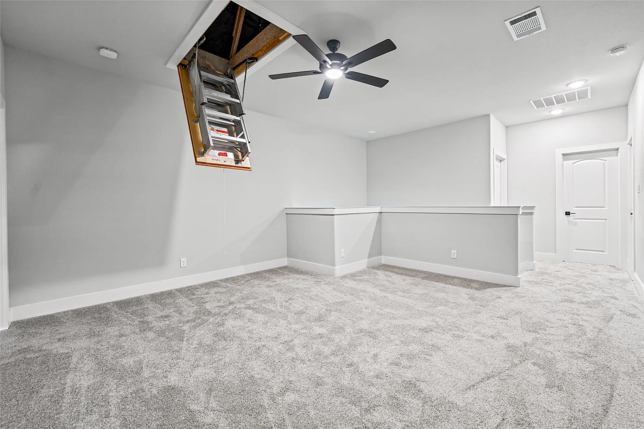 Open loft space featuring plush carpet, a ceiling fan, recessed lighting, and a white paneled door