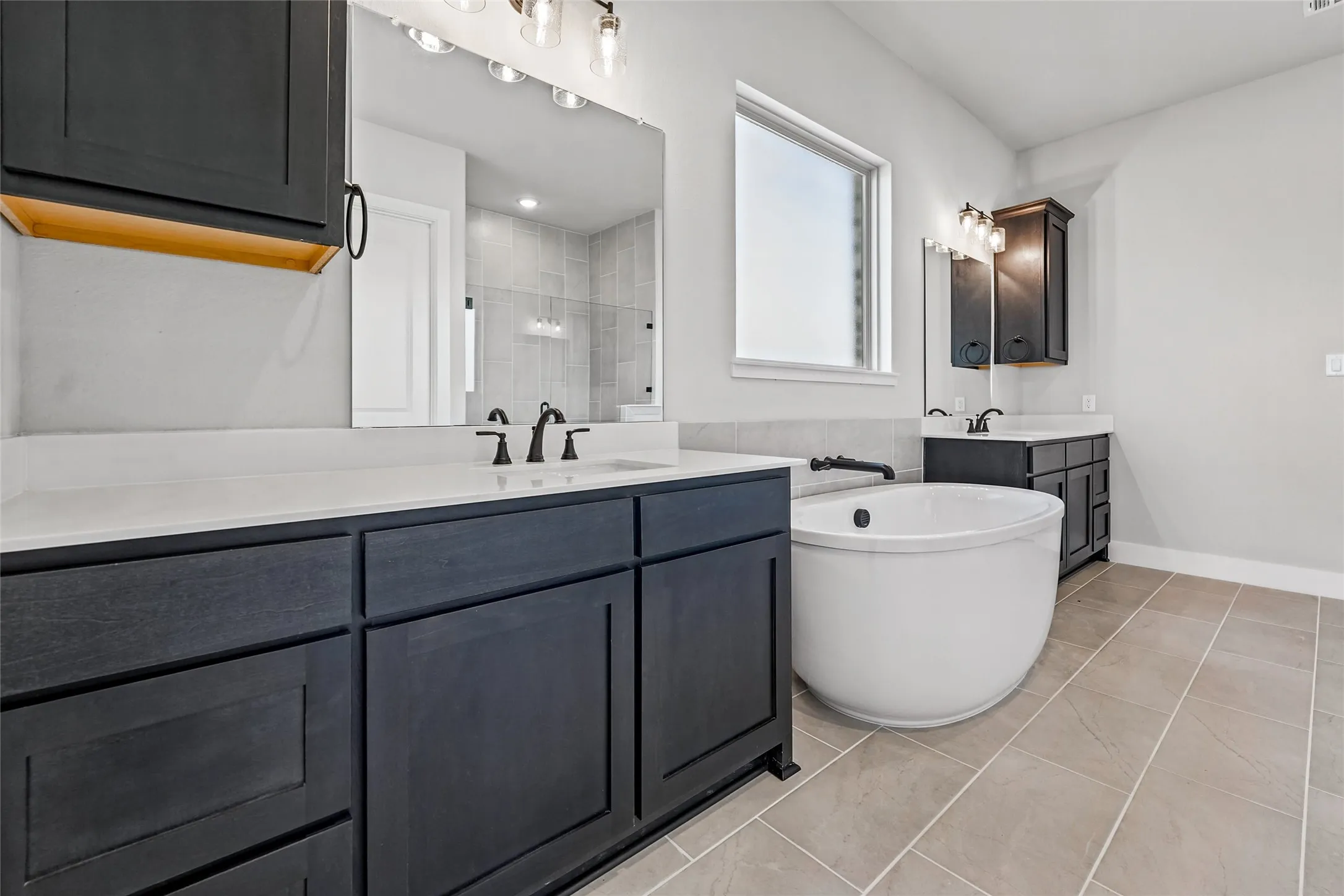 Dual vanities with dark cabinetry and light countertops