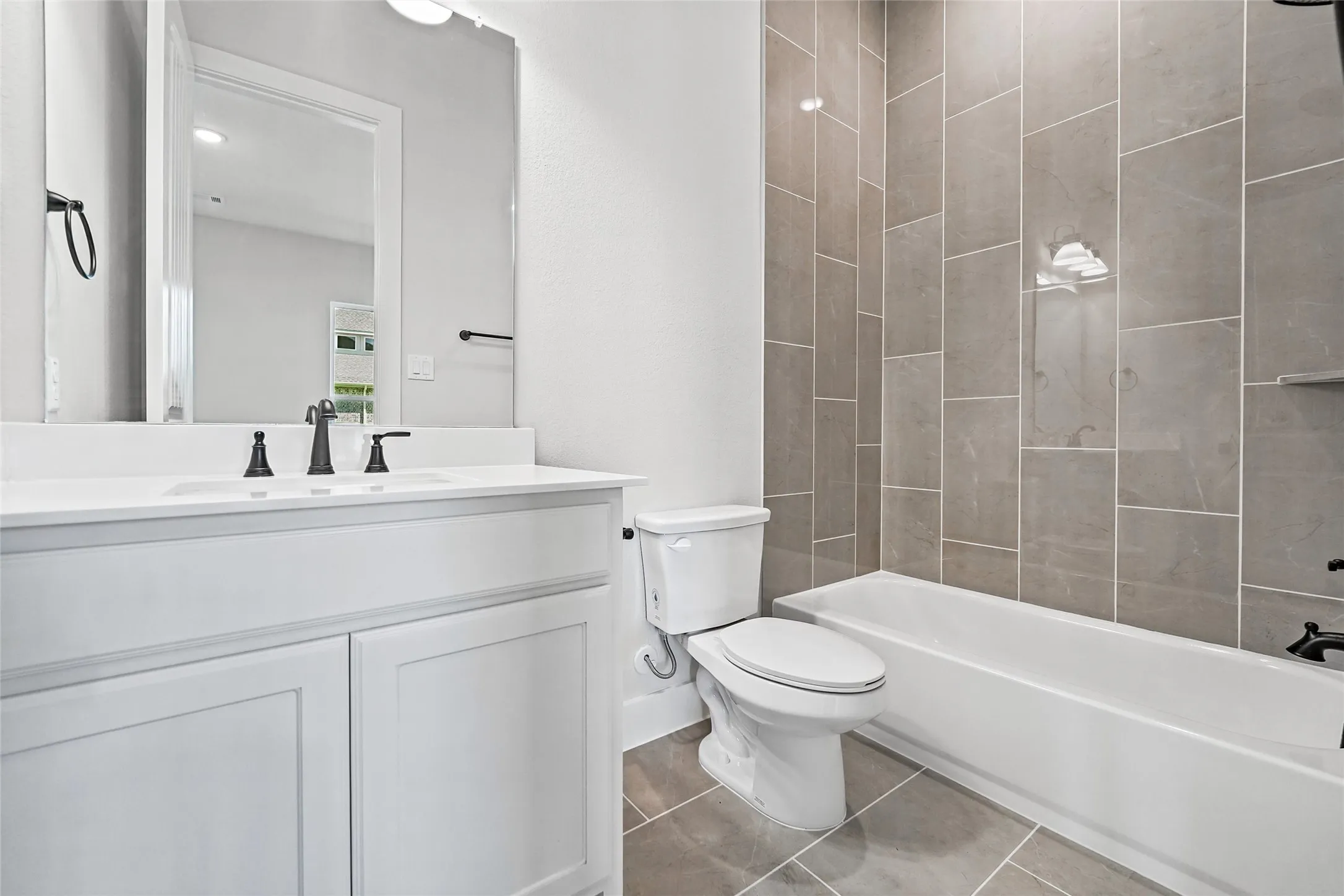 White vanity with integrated sink, matte black faucet, and rectangular mirror