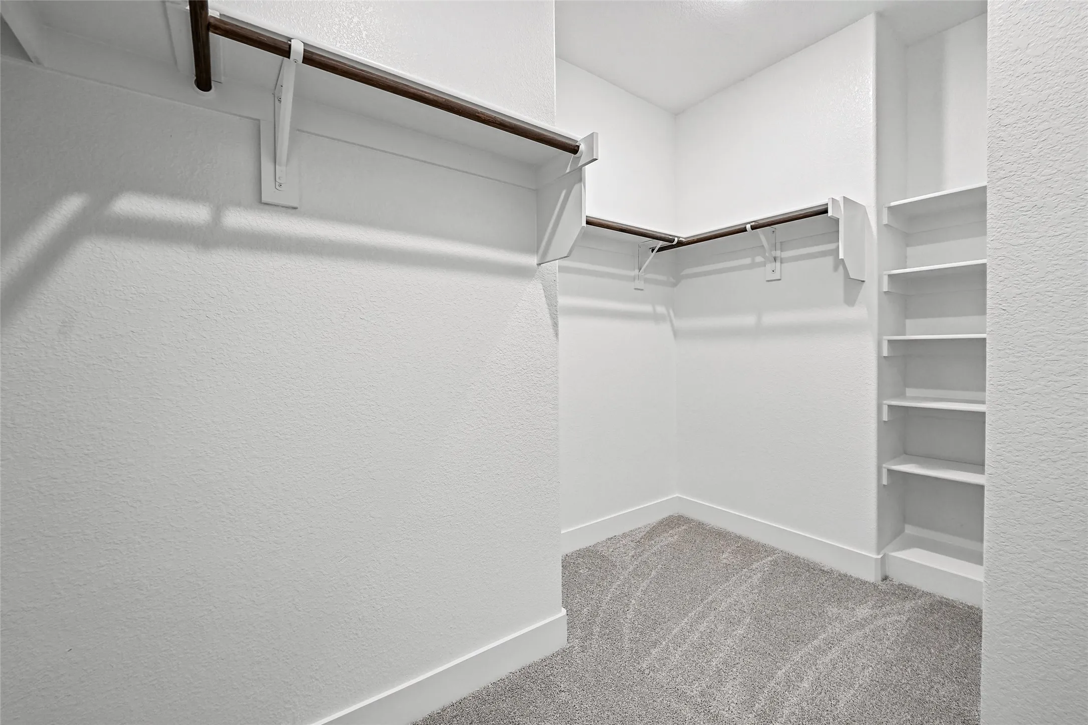 Integrated shelving, multiple hanging rods, and textured carpeting