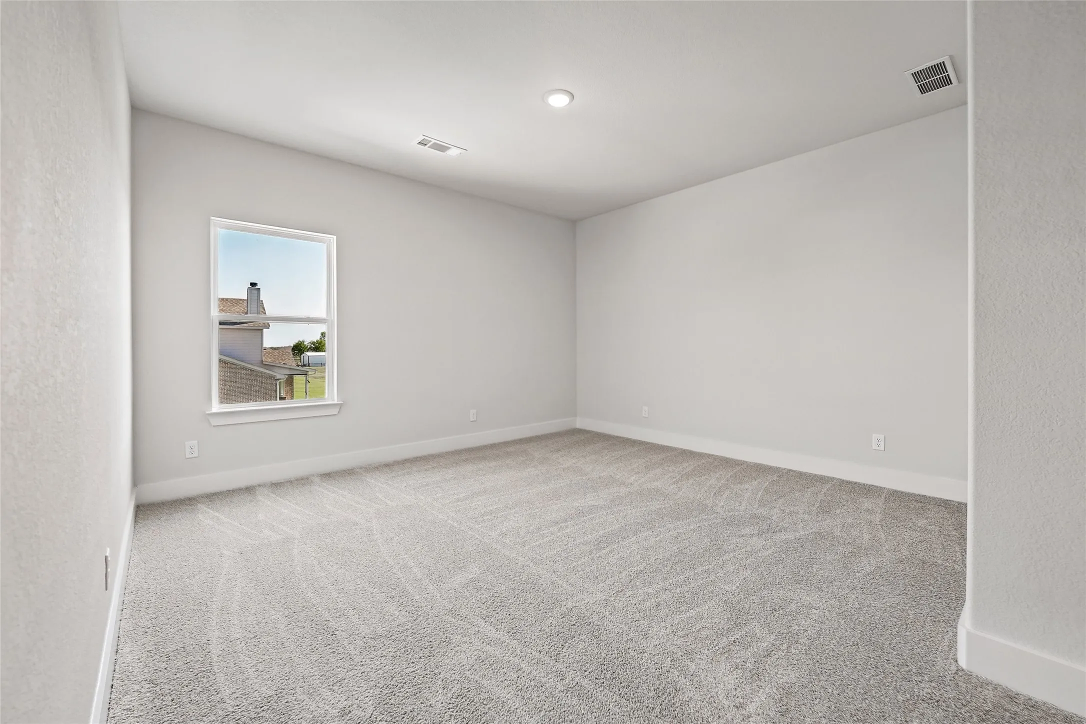Carpeted room featuring a single window, recessed lighting, and light-toned walls