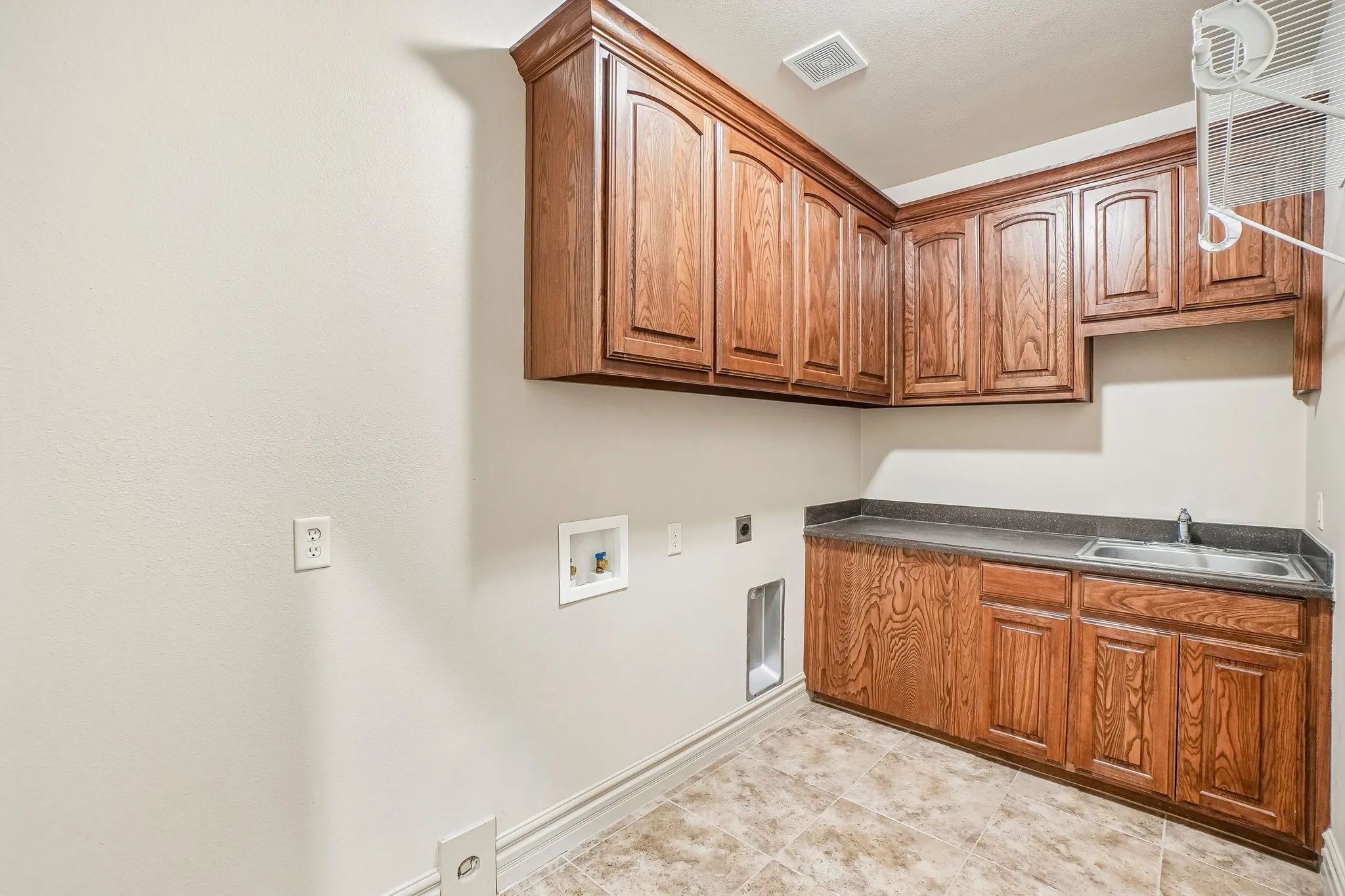 Large utility room with cabinets & sink. Space to add a refrigerator!