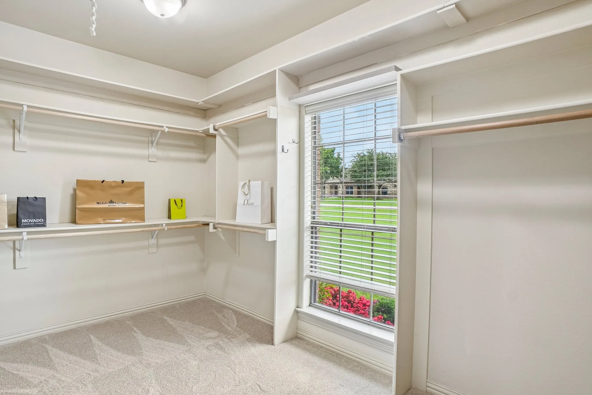 Walk-in closet in primary bathroom with window