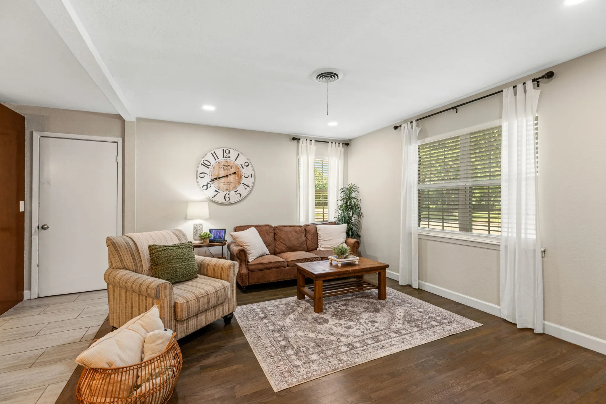 Living area featuring recessed lighting, dark wood-finish flooring, light-toned walls, and multiple windows with blinds