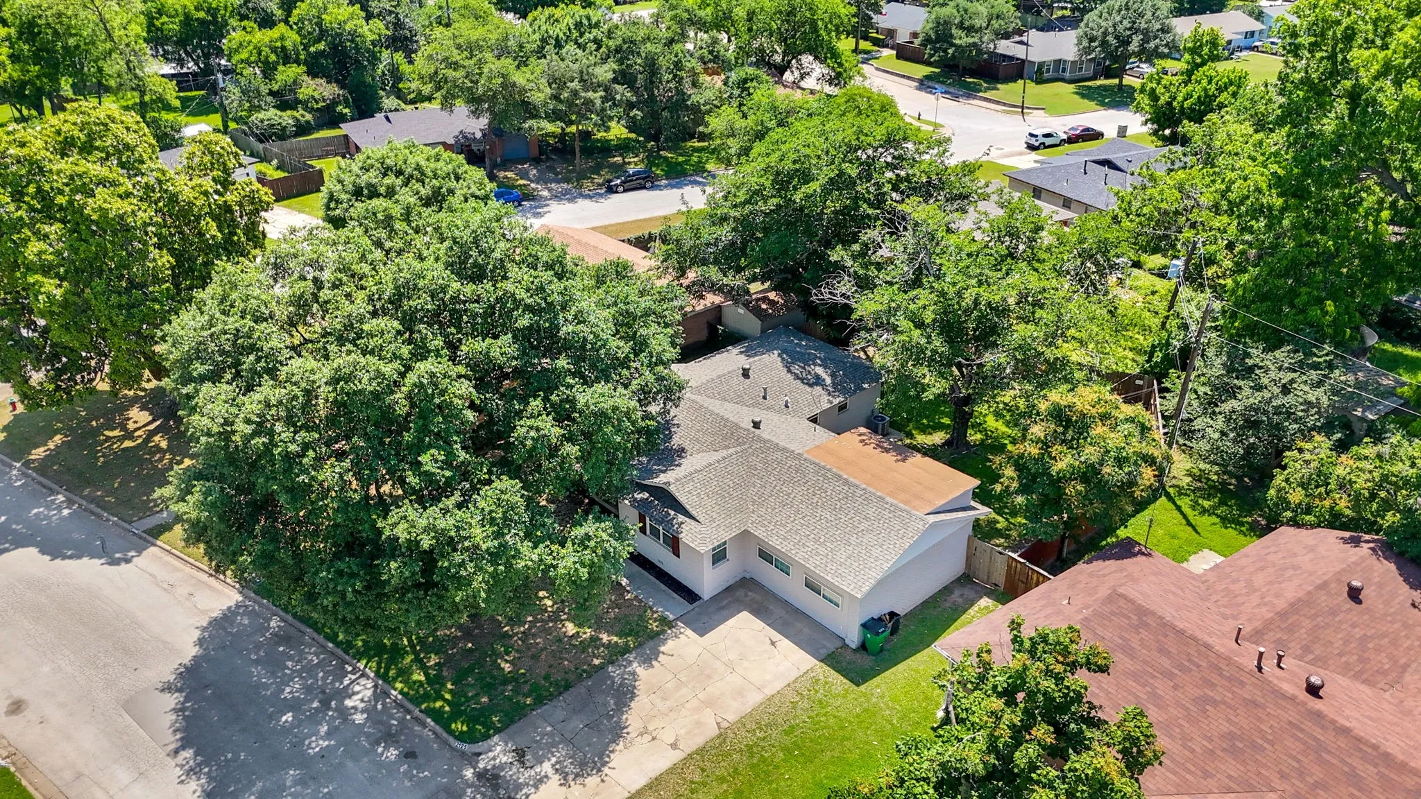 Single-story residence featuring a shingled roof, light-colored exterior, and an attached garage