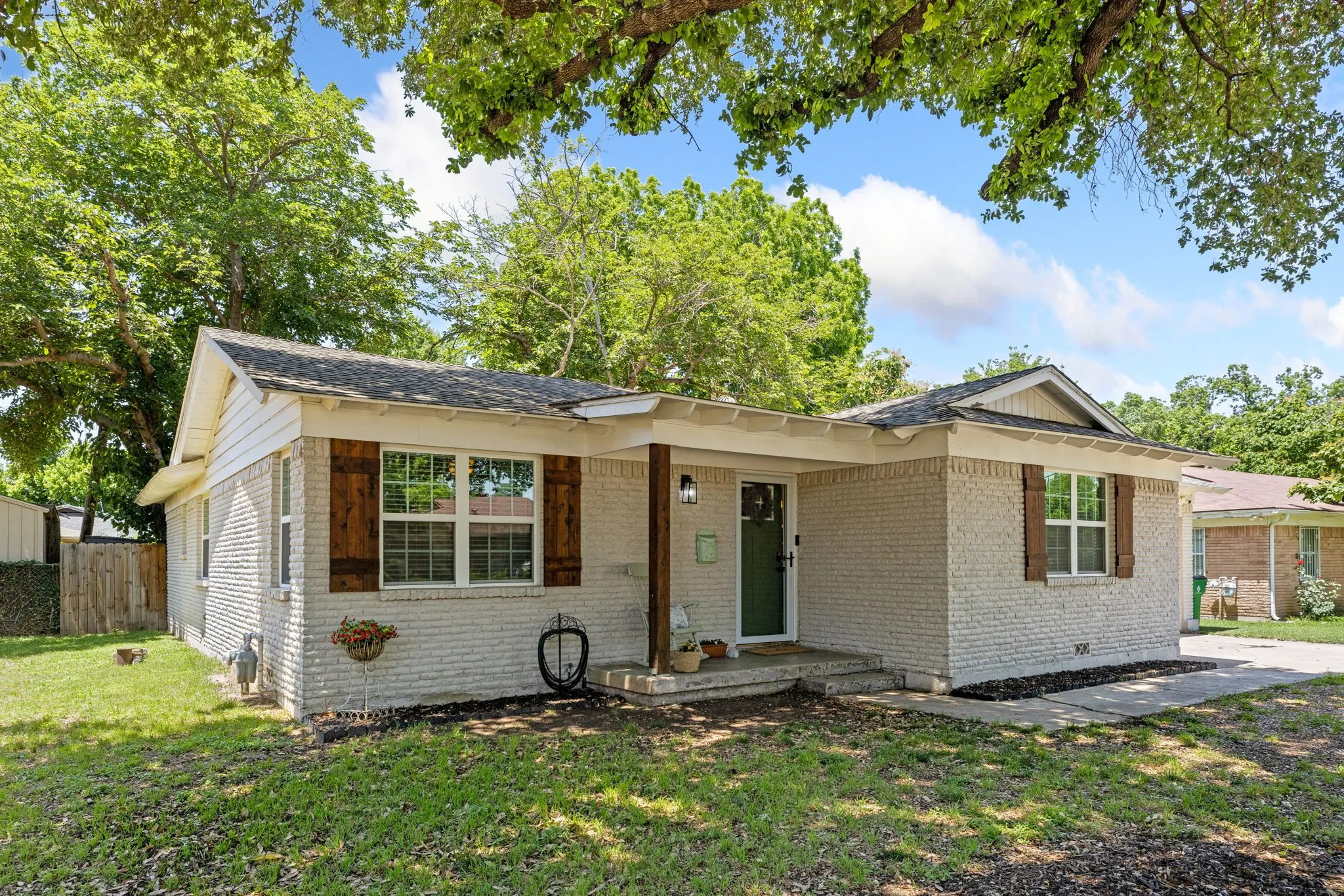 Light-painted brick exterior featuring wood shutters and a prominent front porch