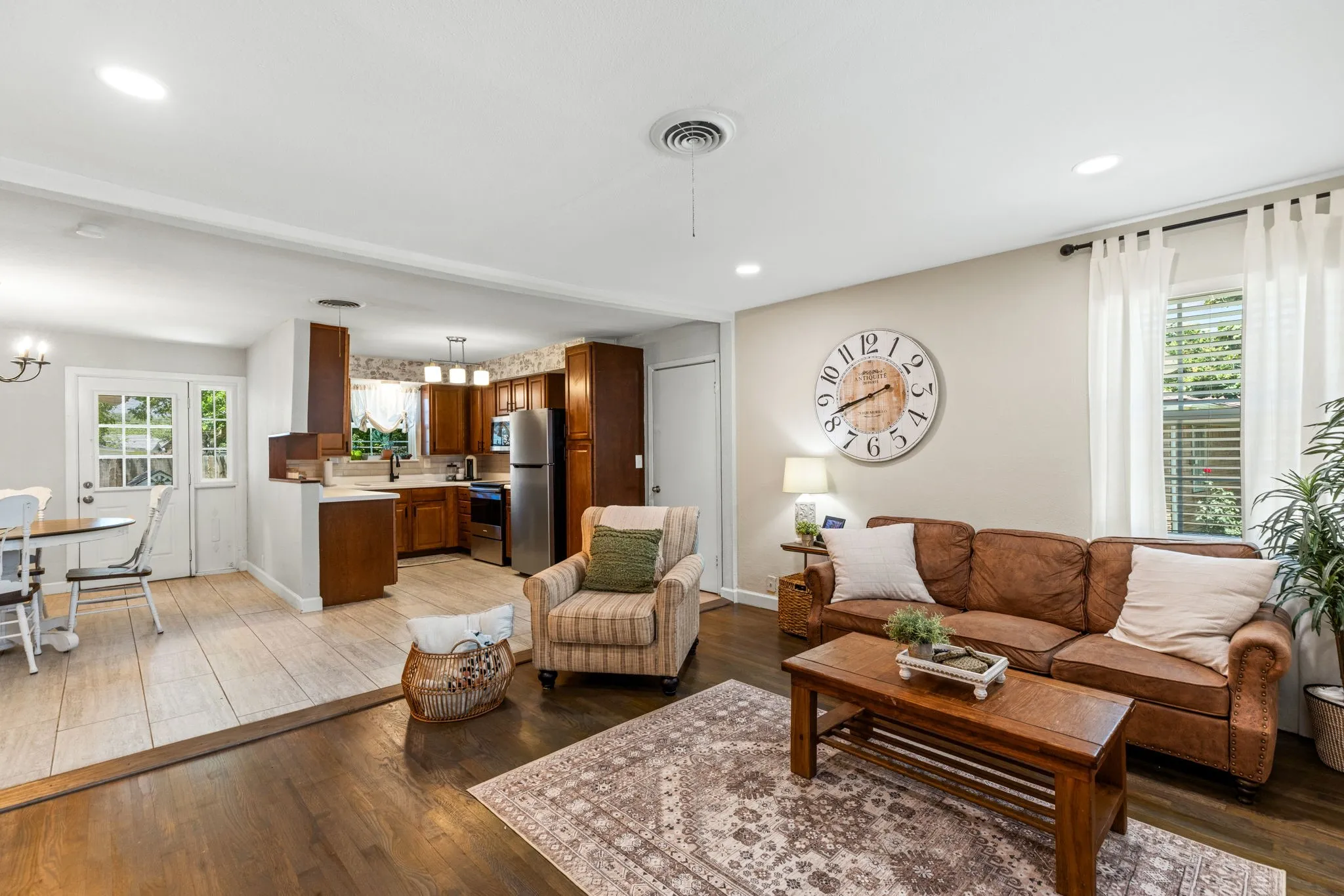 Open-concept living area featuring rich wood-finish flooring, recessed lighting, and a light-toned wall color