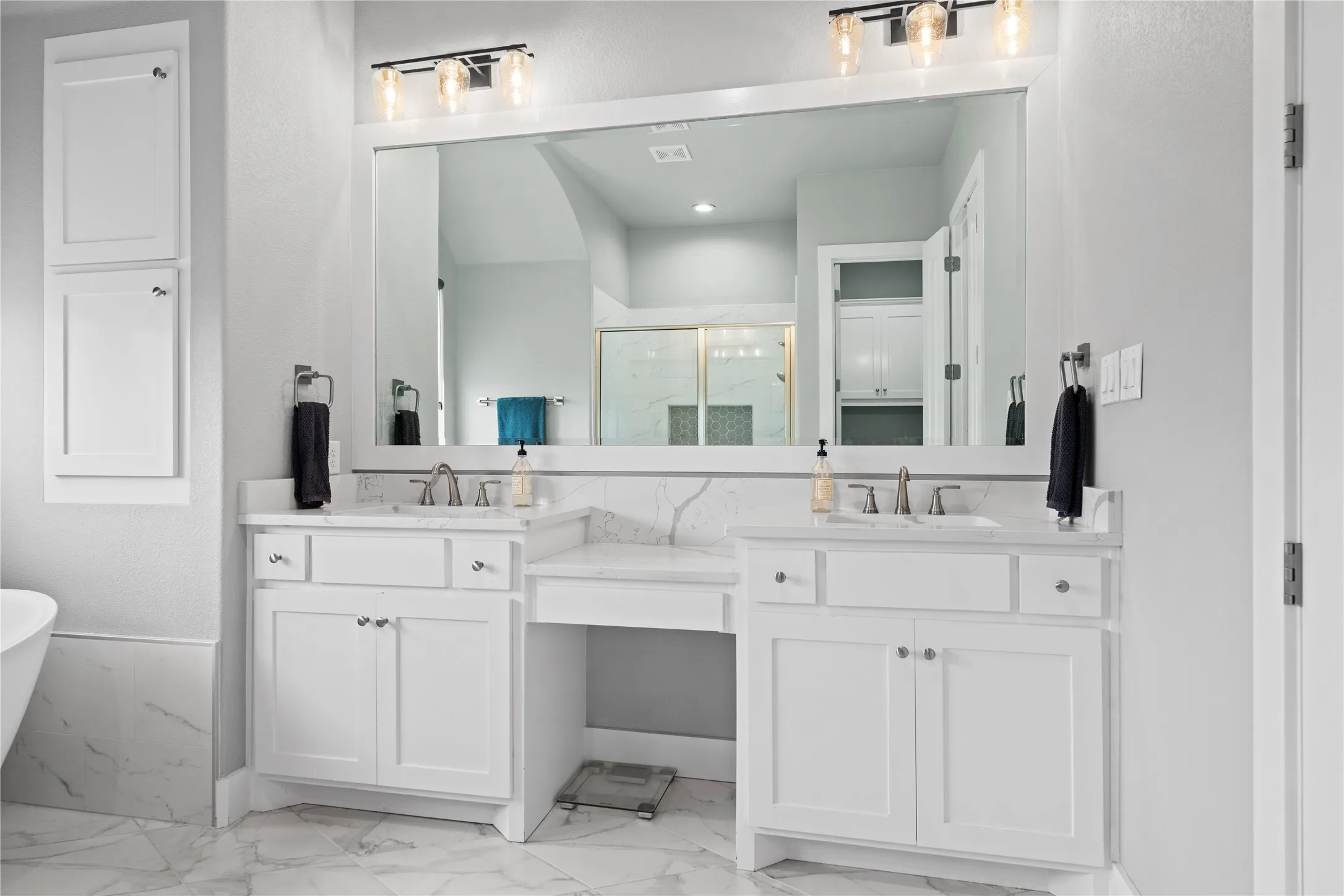 Dual vanity with individual sinks, white cabinetry, and a spacious countertop