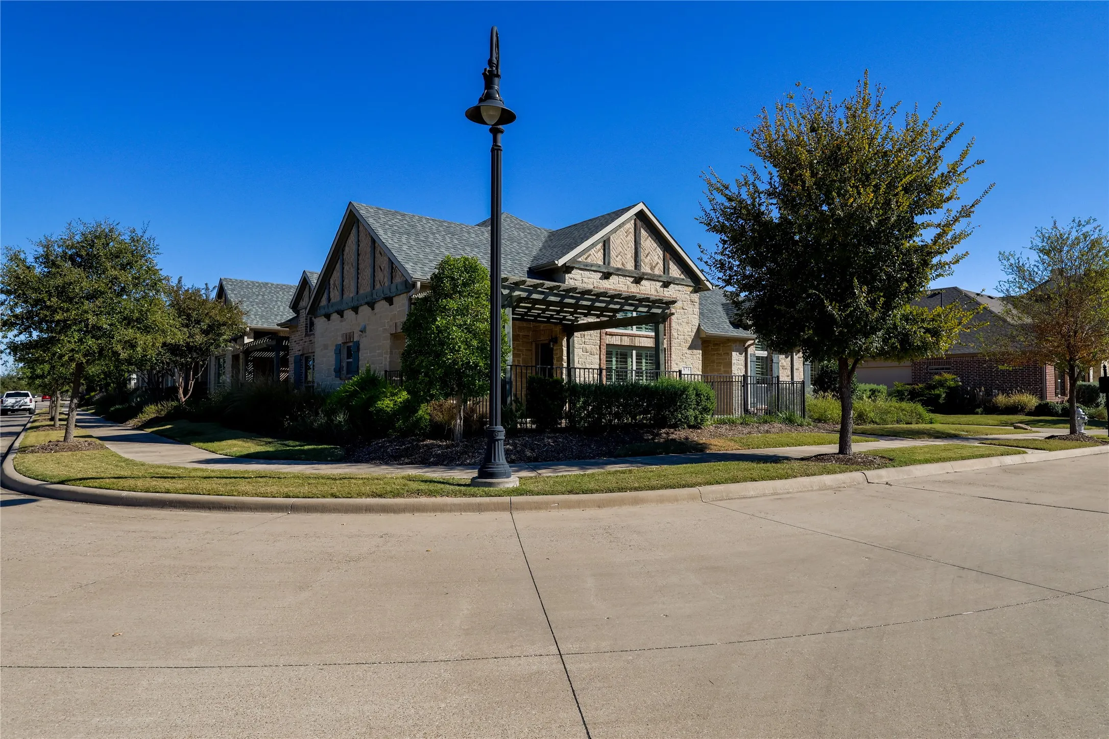 Corner lot property featuring a light brick facade and dark trim details