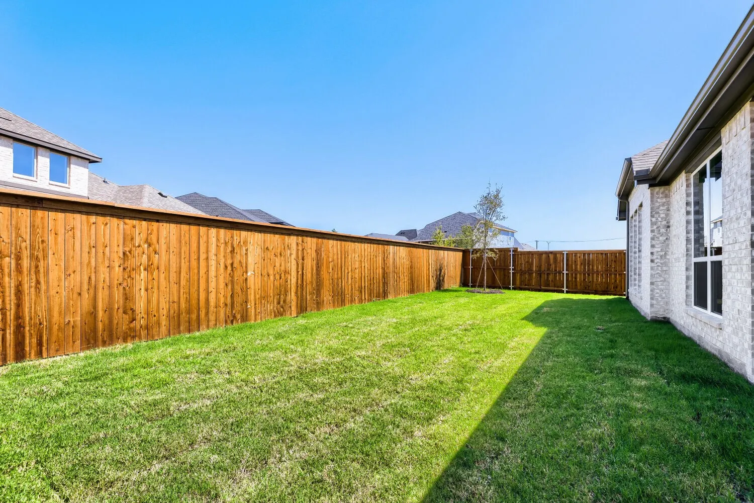 Expansive fenced yard with a manicured lawn
