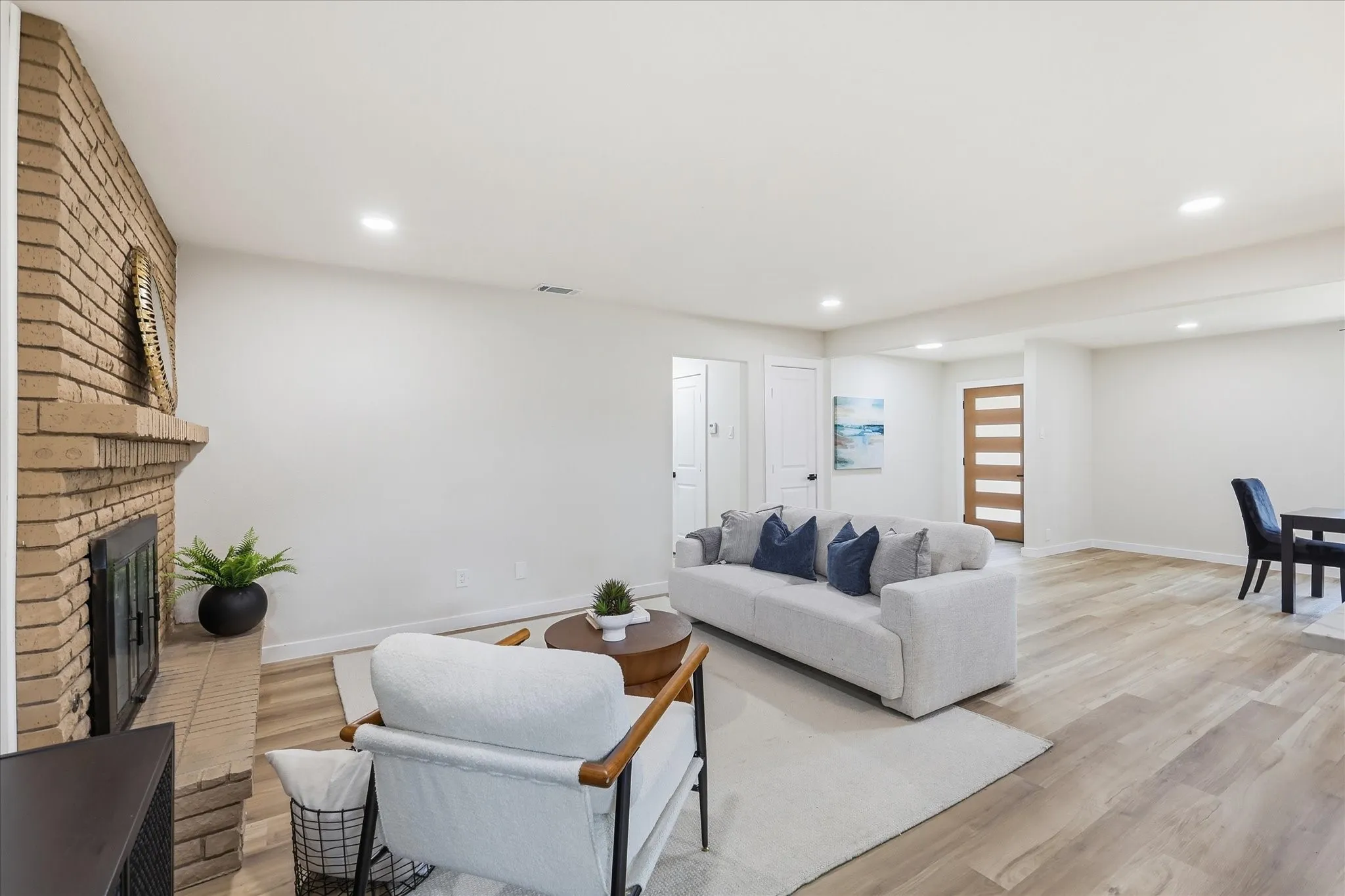 Living area featuring a brick fireplace, recessed lighting, and wood-finish flooring