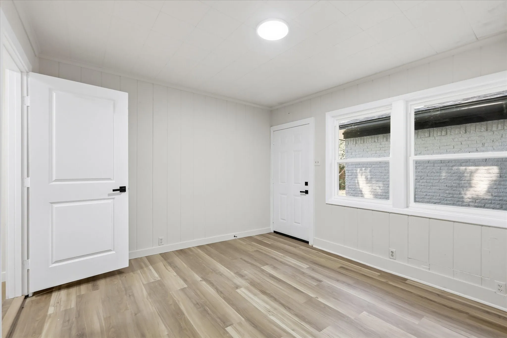 Neutral-toned room featuring light wood-finish flooring