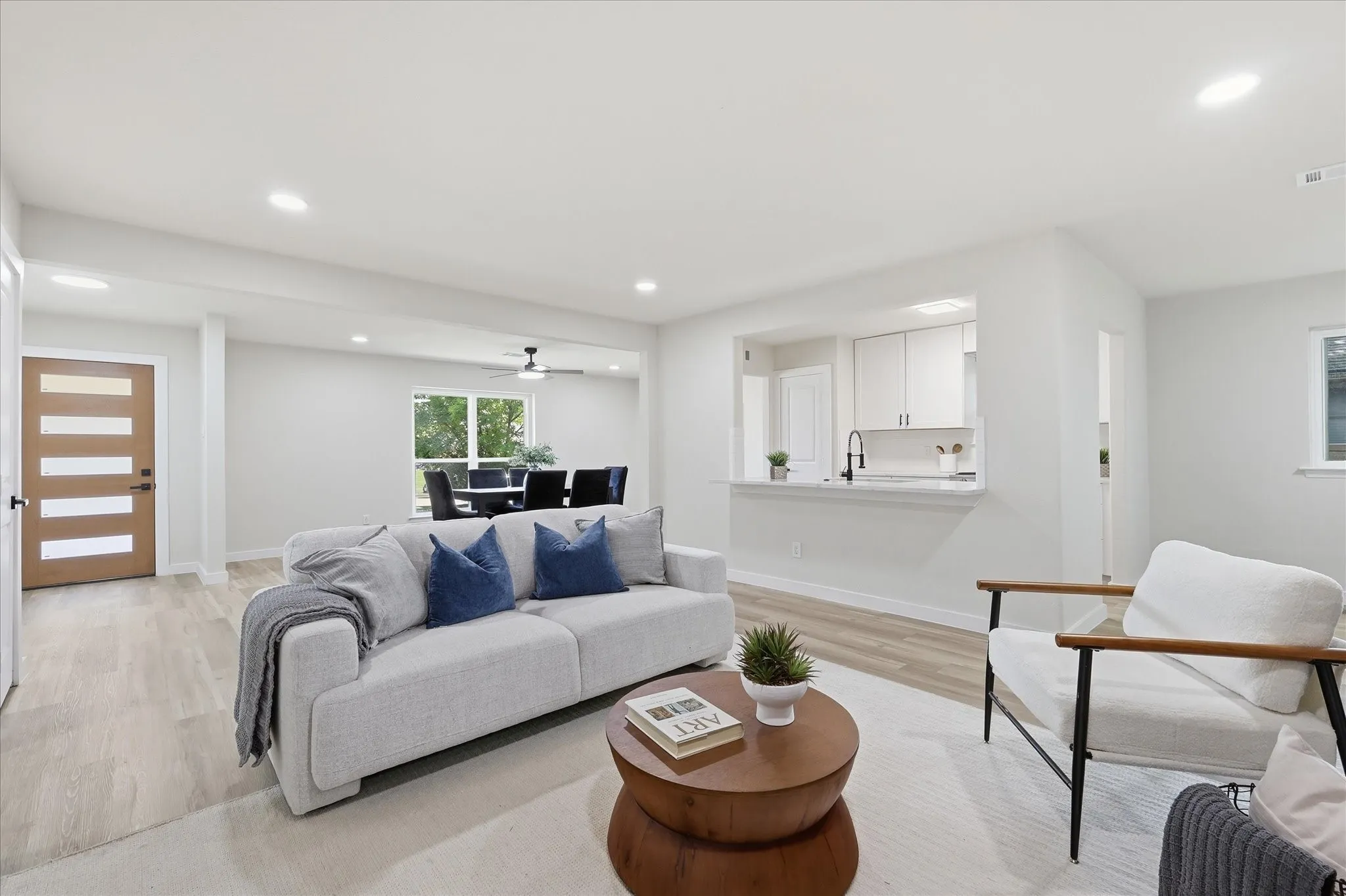 Open-concept living area featuring light wood-finish flooring and recessed lighting