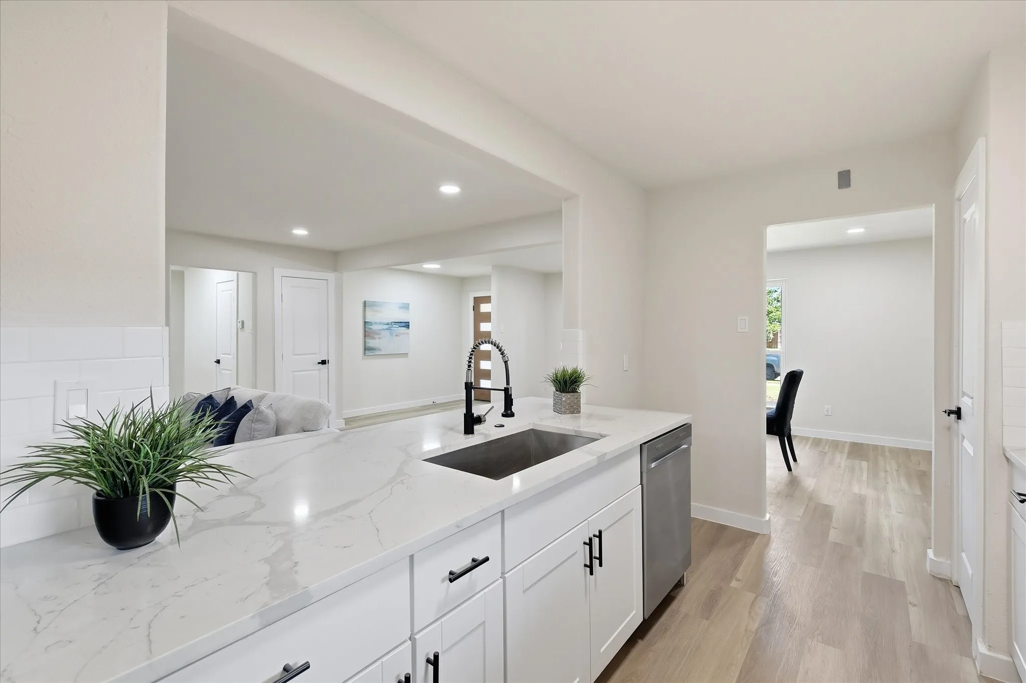 Kitchen featuring white cabinetry, a large single-basin sink with a matte black faucet, and a stainless steel dishwasher