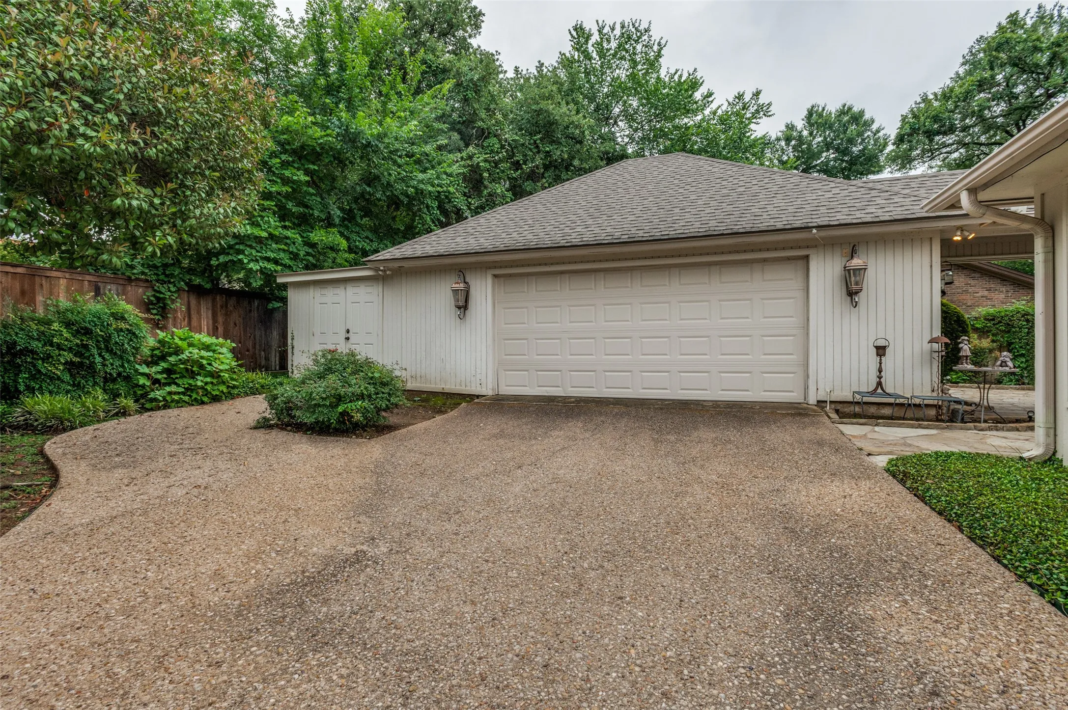 Two-car garage with white panel door and vertical siding