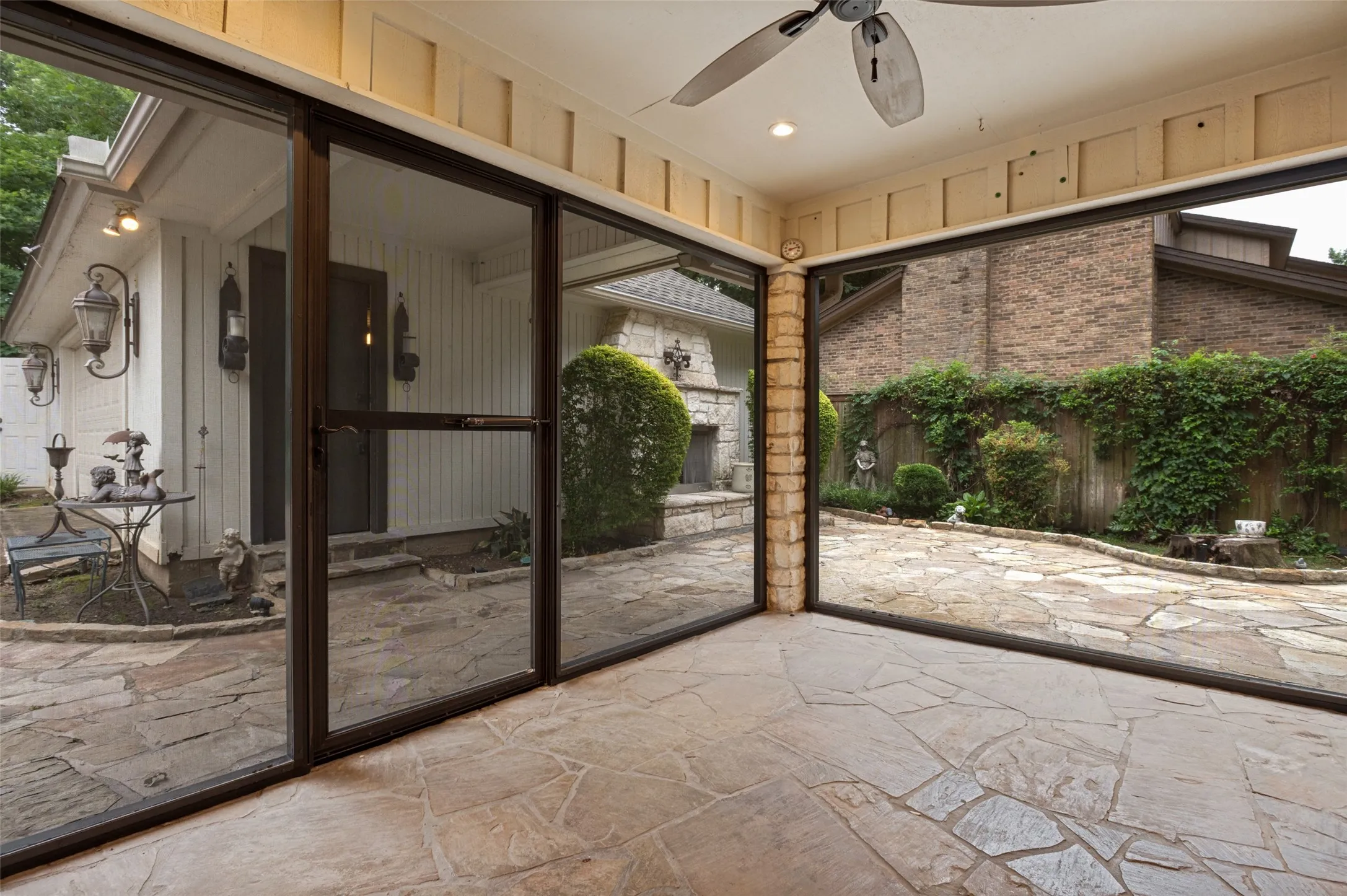 Screened patio featuring flagstone flooring, a ceiling fan, and recessed lighting