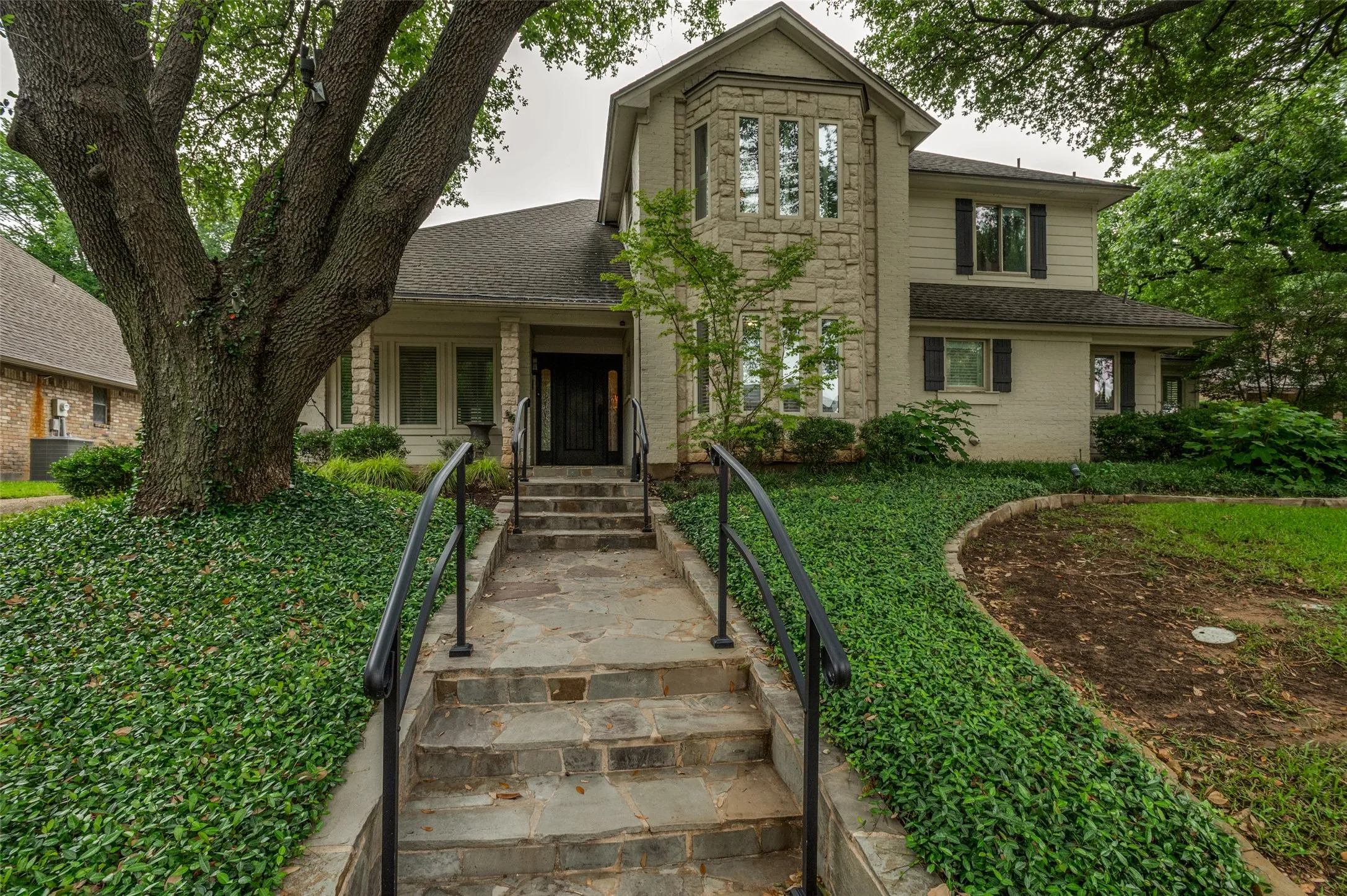 Stone facade residence with a stone staircase and wrought iron railings