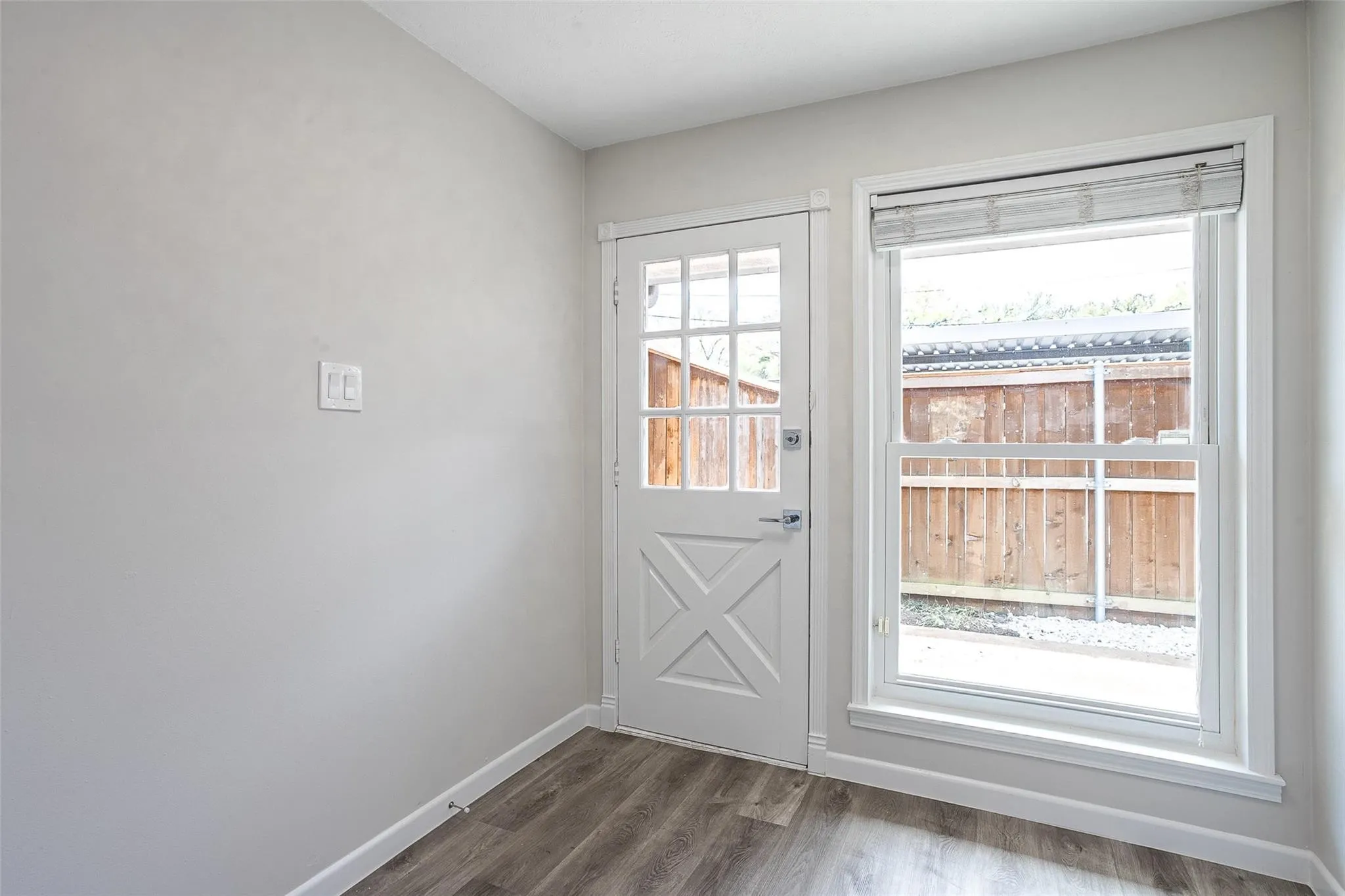 Entryway featuring a white paneled door with glass inserts and a single-hung window with blinds