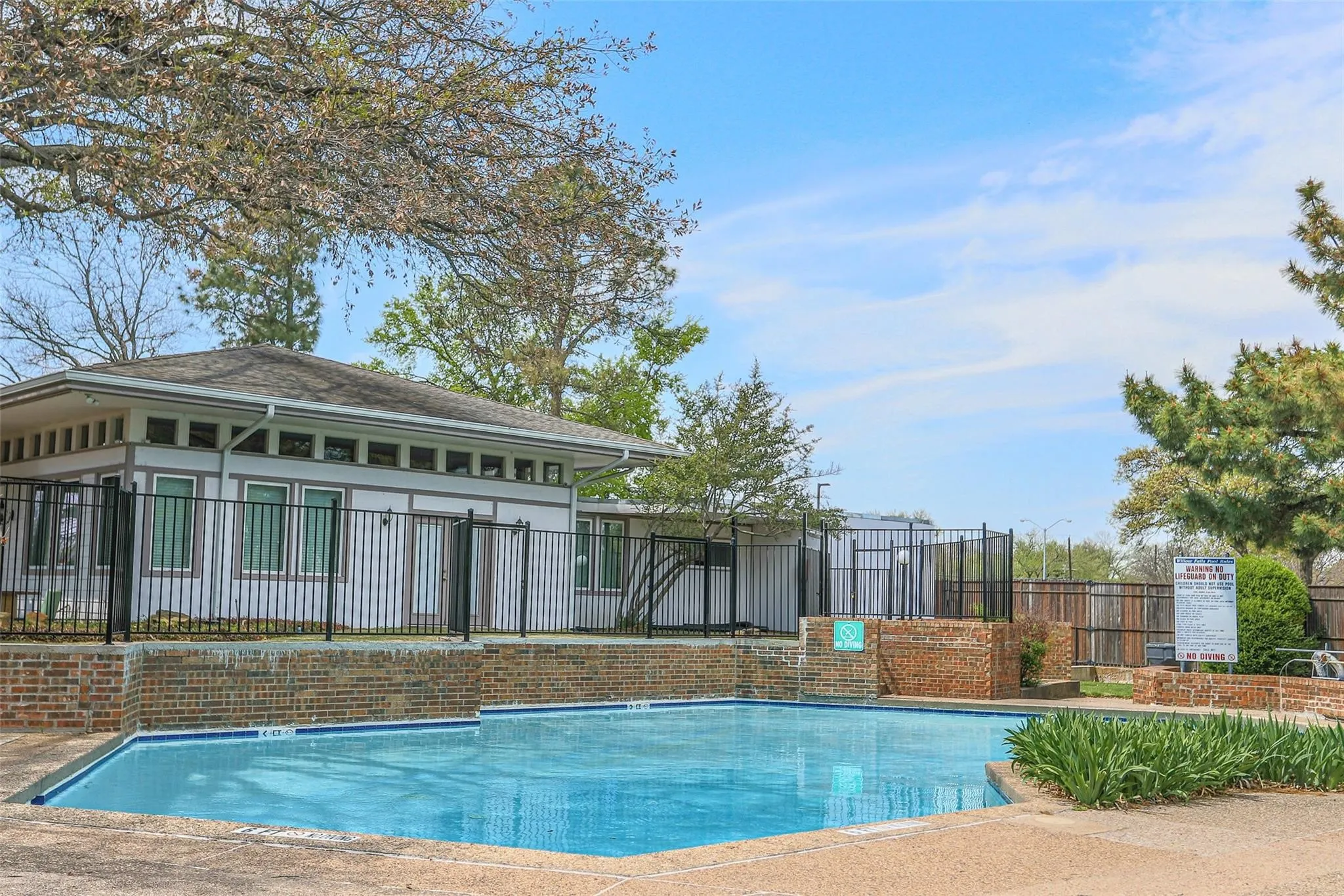 Outdoor swimming pool (community pool)with brick surround and concrete decking