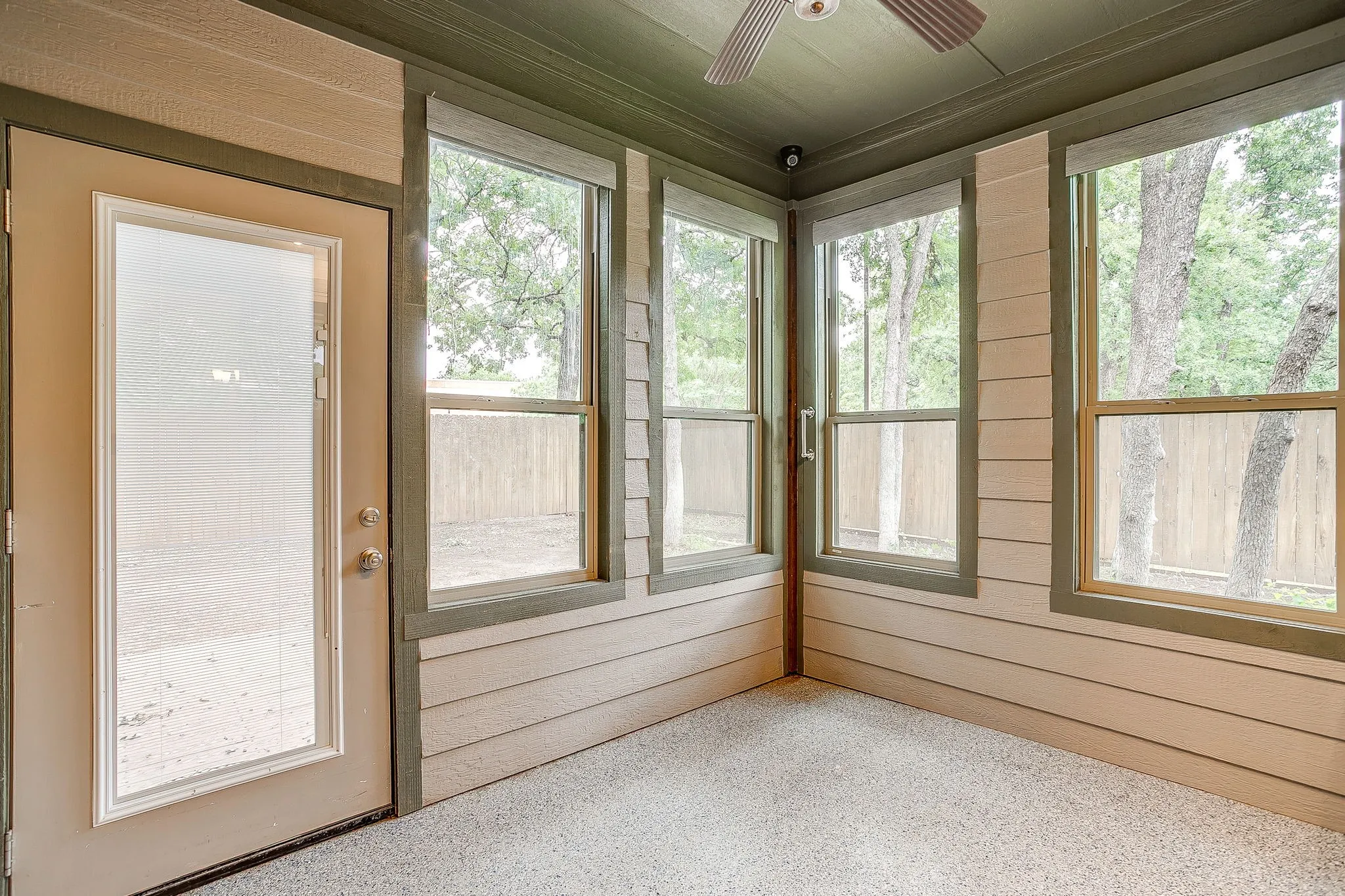 Closed in patio/porch with automatic window shades, celing fan and epoxy floor.