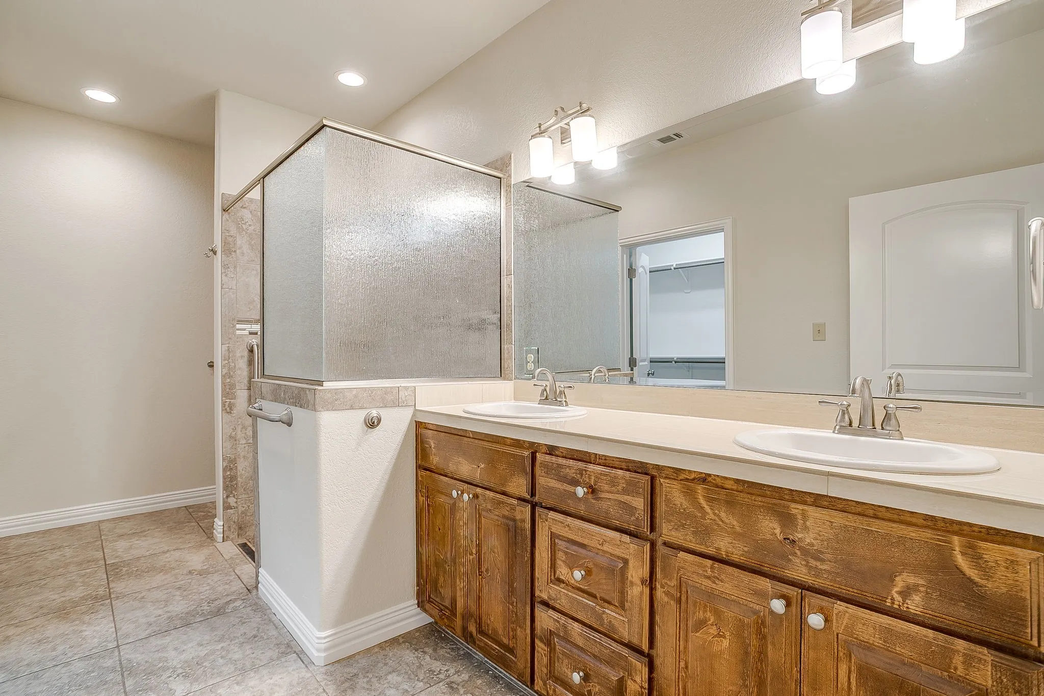 Master bath with large shower, tile floors, double vanity with tile counter. Not seen to the left is a very large master closet.