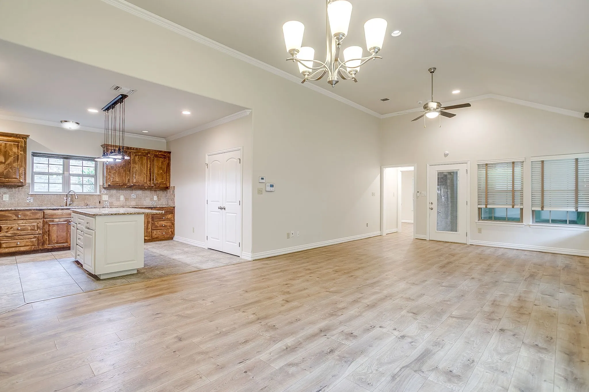 Another view of living /dining combo with open access directly in to kitchen. Kitchen island painted to match wall color. Back door leads to closed in porch and back yard. The beautiful floors are the perfect color.