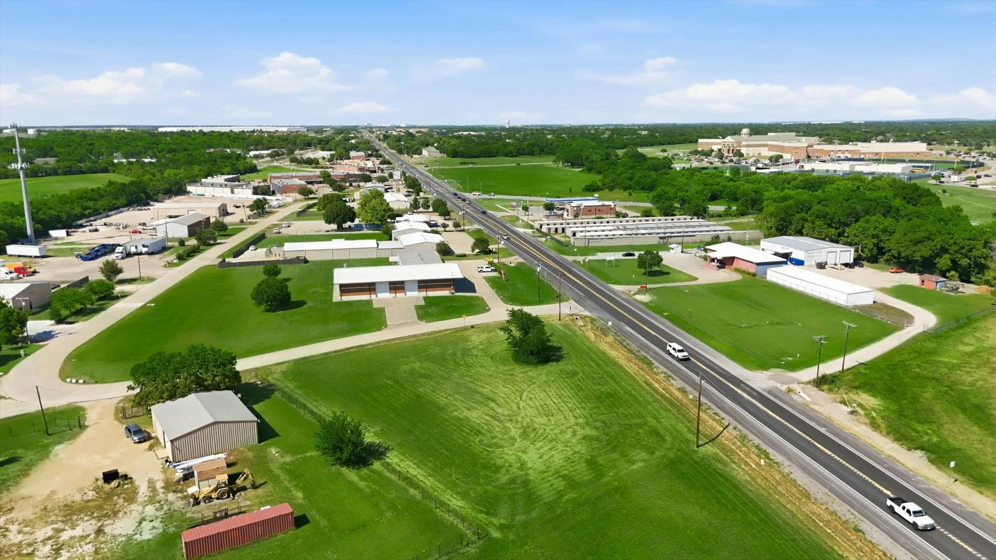 Expansive land parcels with multiple commercial structures, including a metal-roofed building and an extended warehouse-style facility