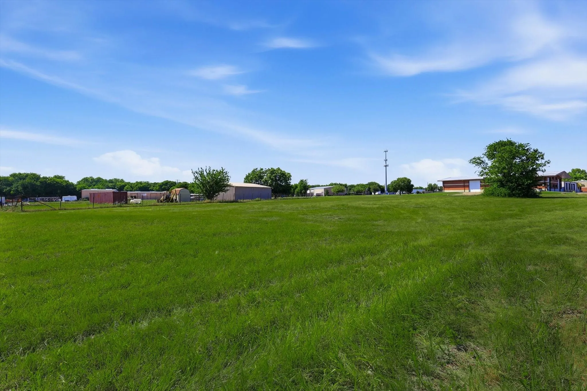 Expansive green field with a clear blue sky overhead