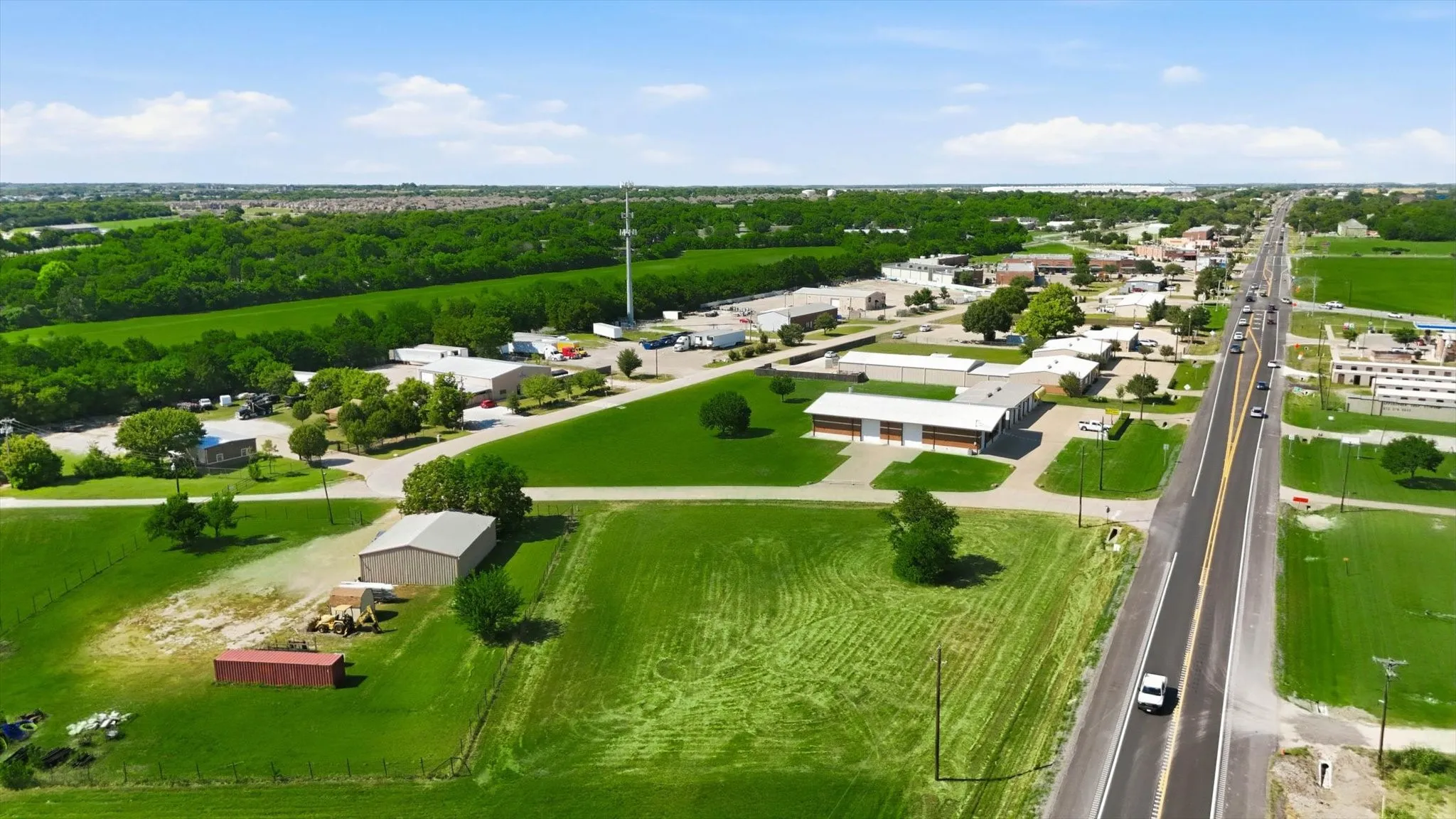 Extensive green spaces with scattered trees and clear skies