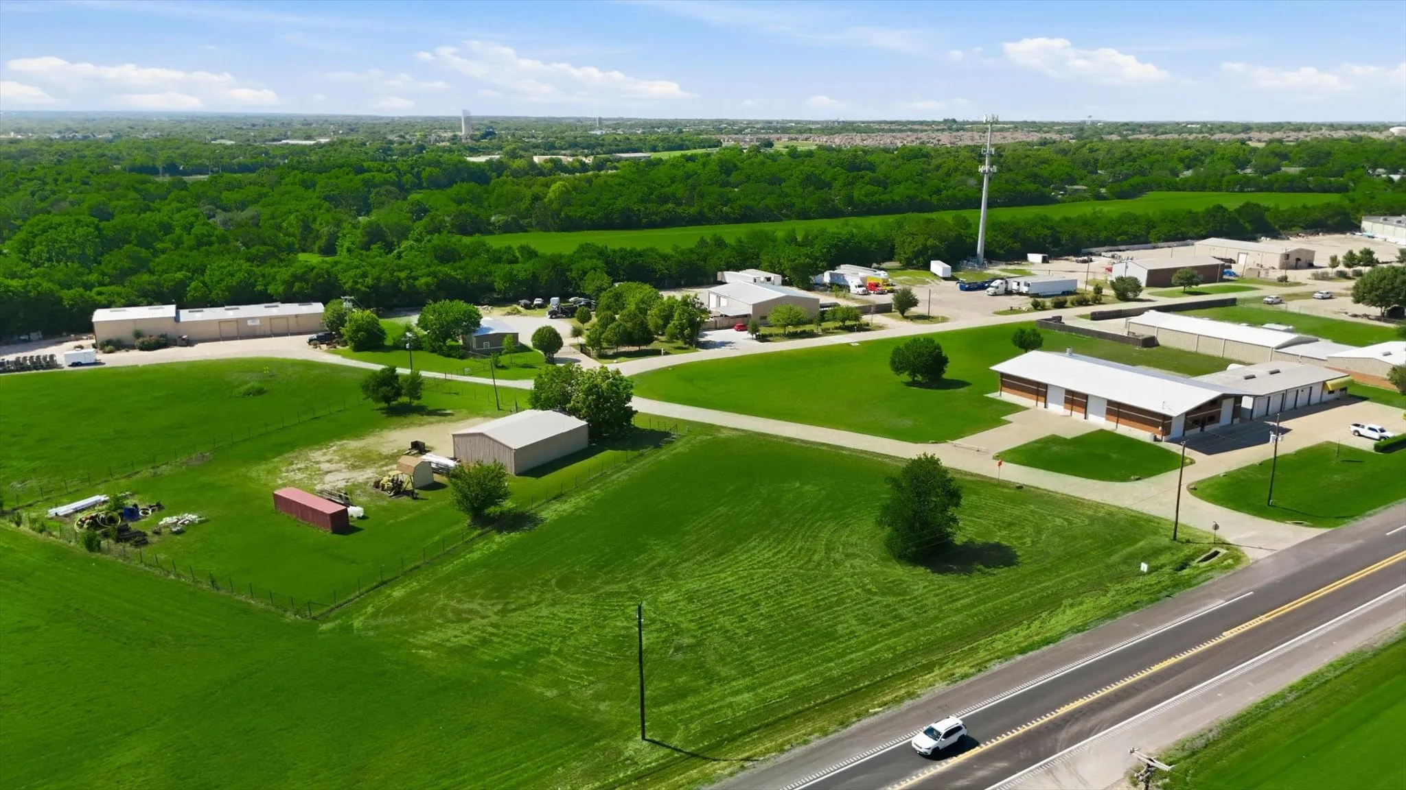 Expansive green fields surrounding commercial and industrial buildings