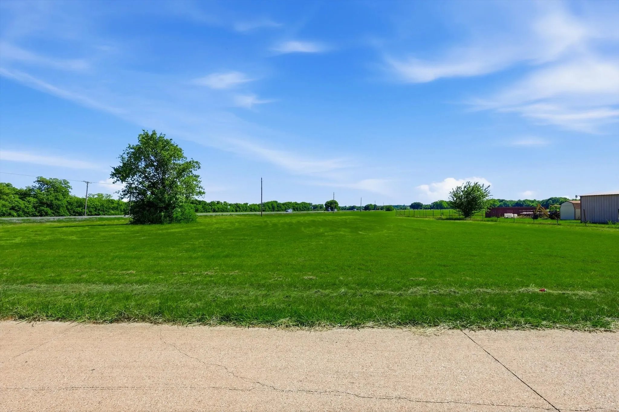 Expansive green lot featuring mature trees and a clear perimeter
